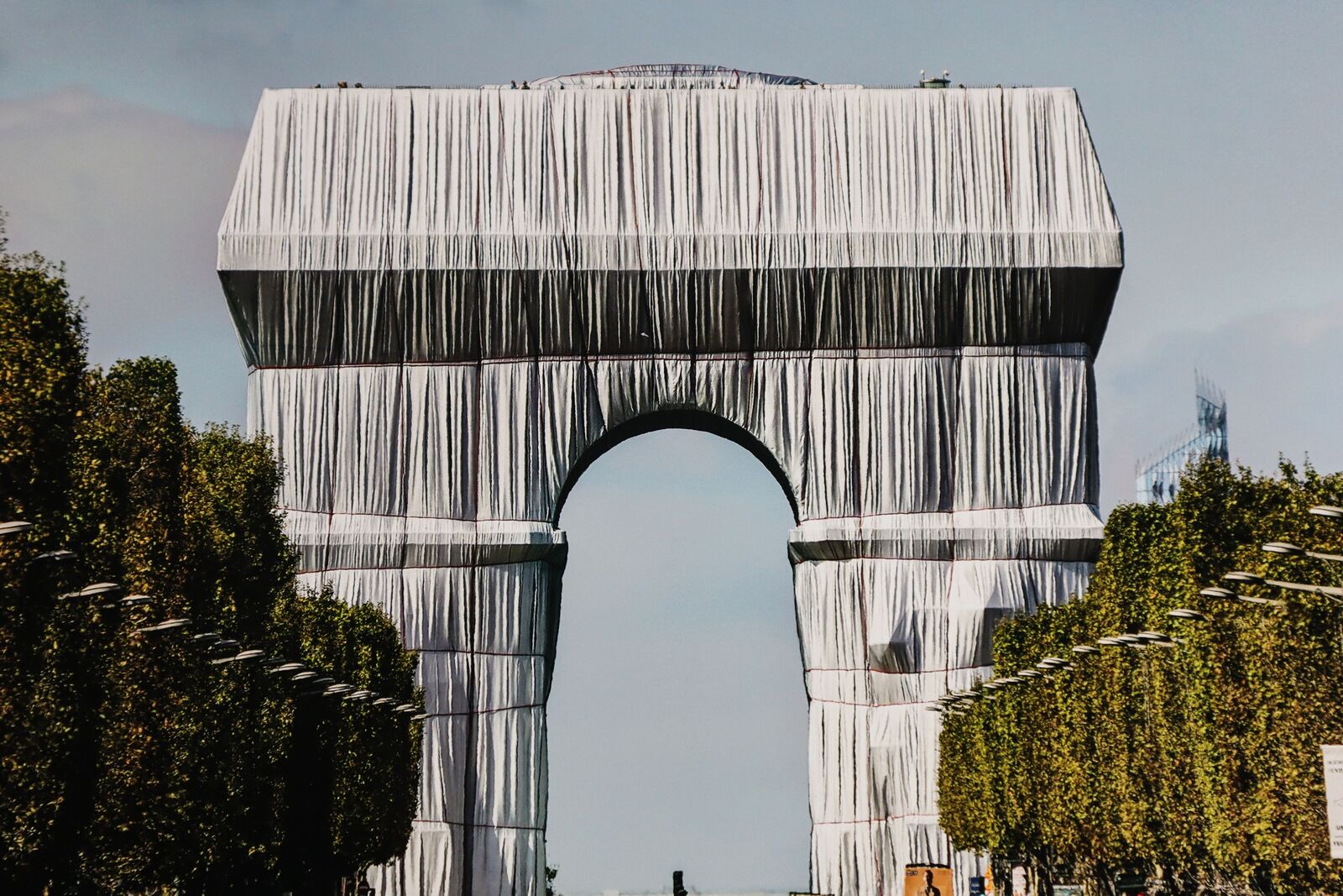 A large metal archway in the middle of a city.