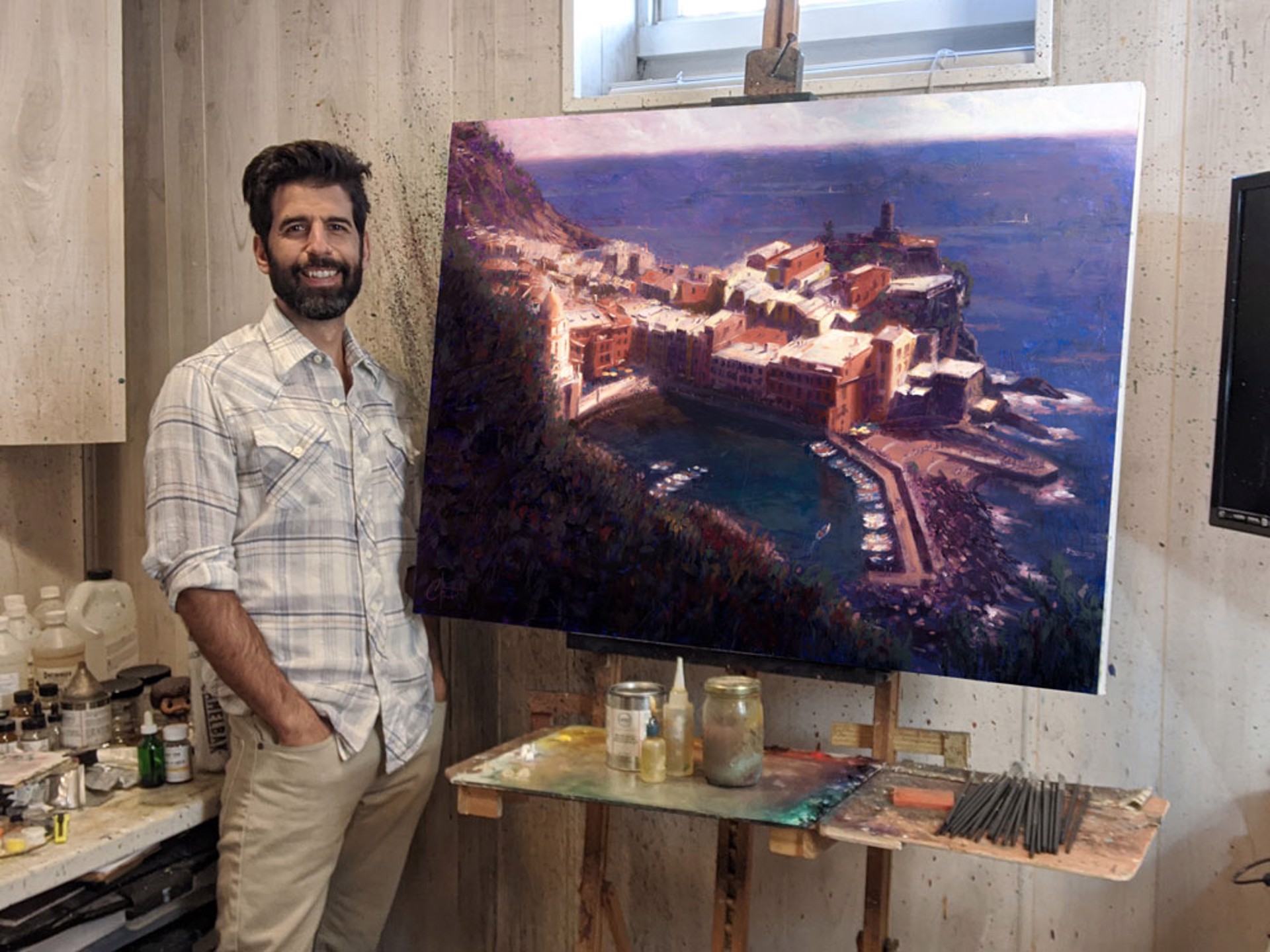 A coastal village nestled on a cliffside overlooking the sea, painted in warm ochre tones against deep blues.