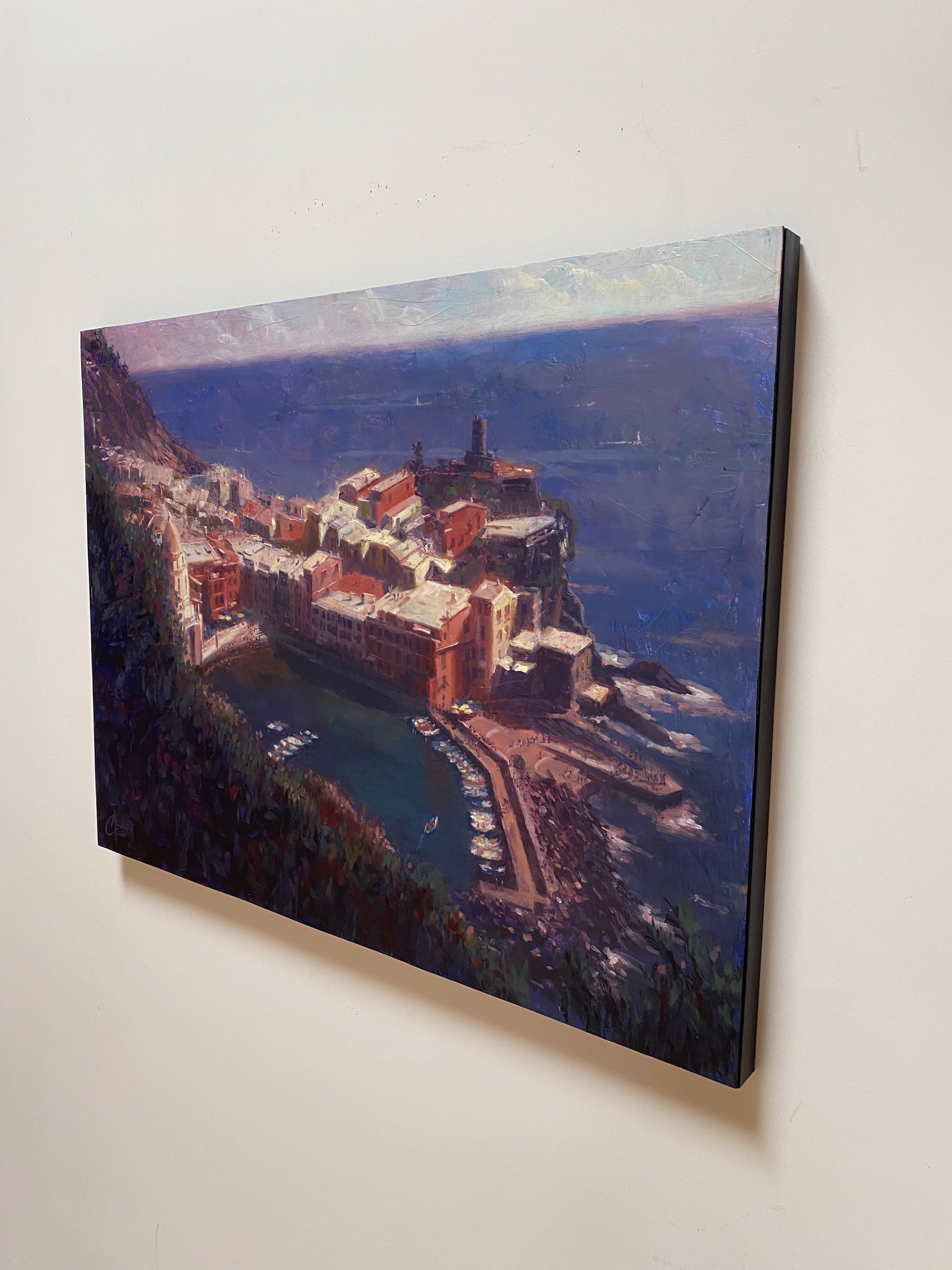 A coastal village nestled on a cliffside overlooking the sea, painted in warm ochre tones against deep blues.