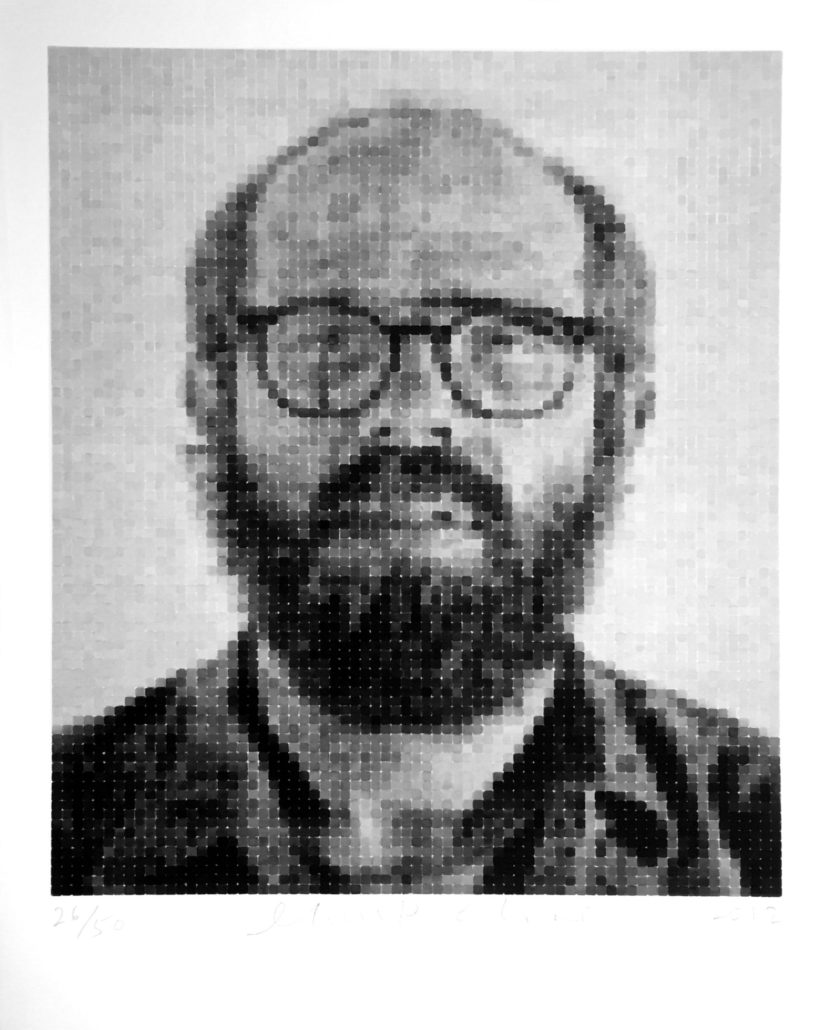 A black and white photo of a man with glasses.