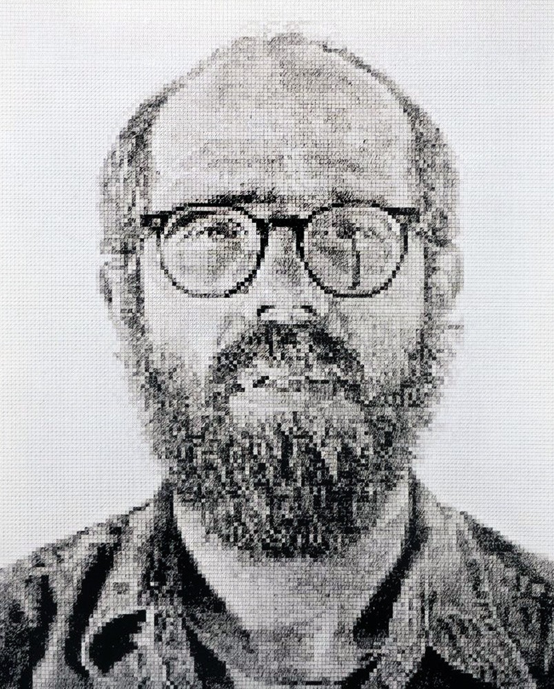 A black and white photo of a man with glasses and a beard.