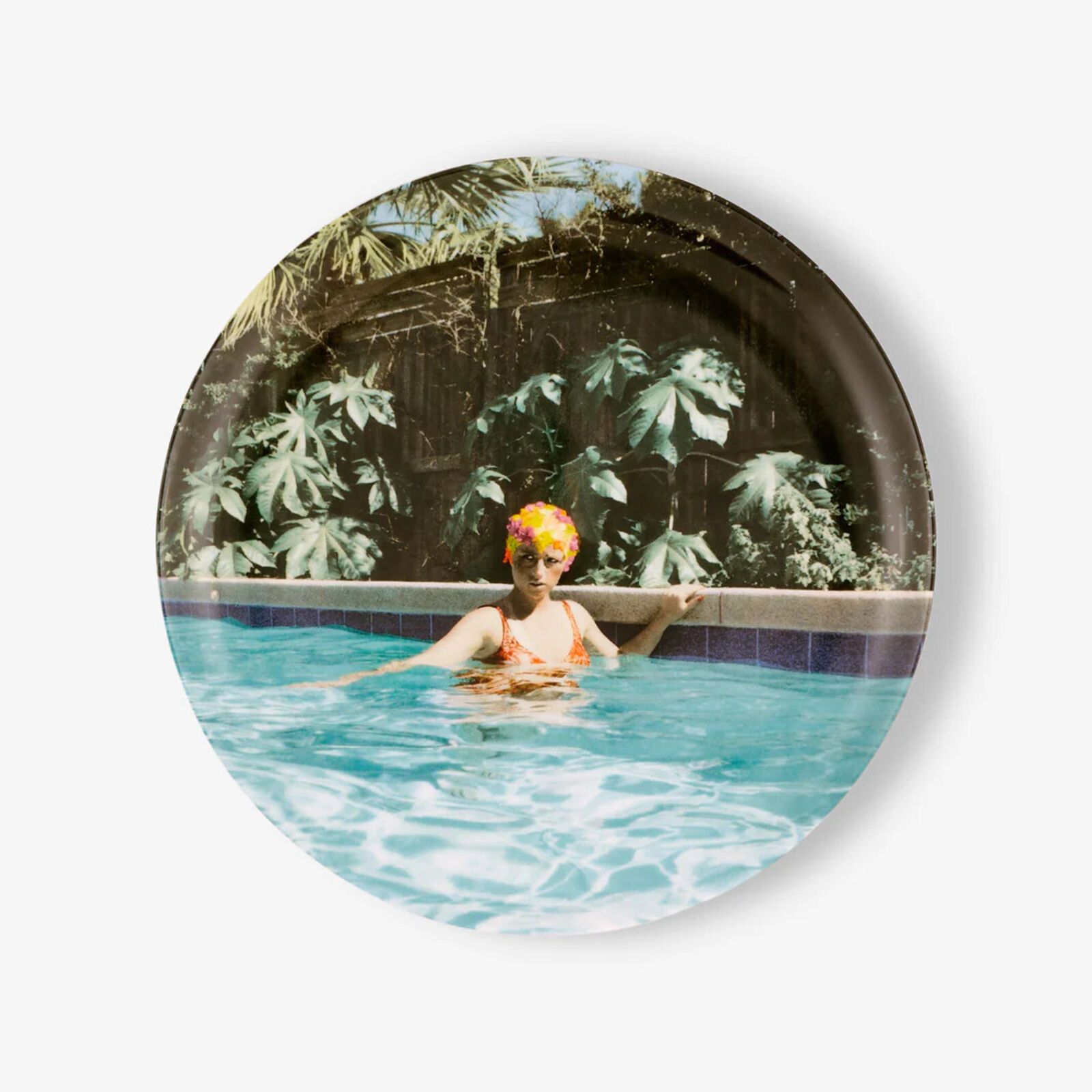 A plate with a picture of a woman in a swimming pool.