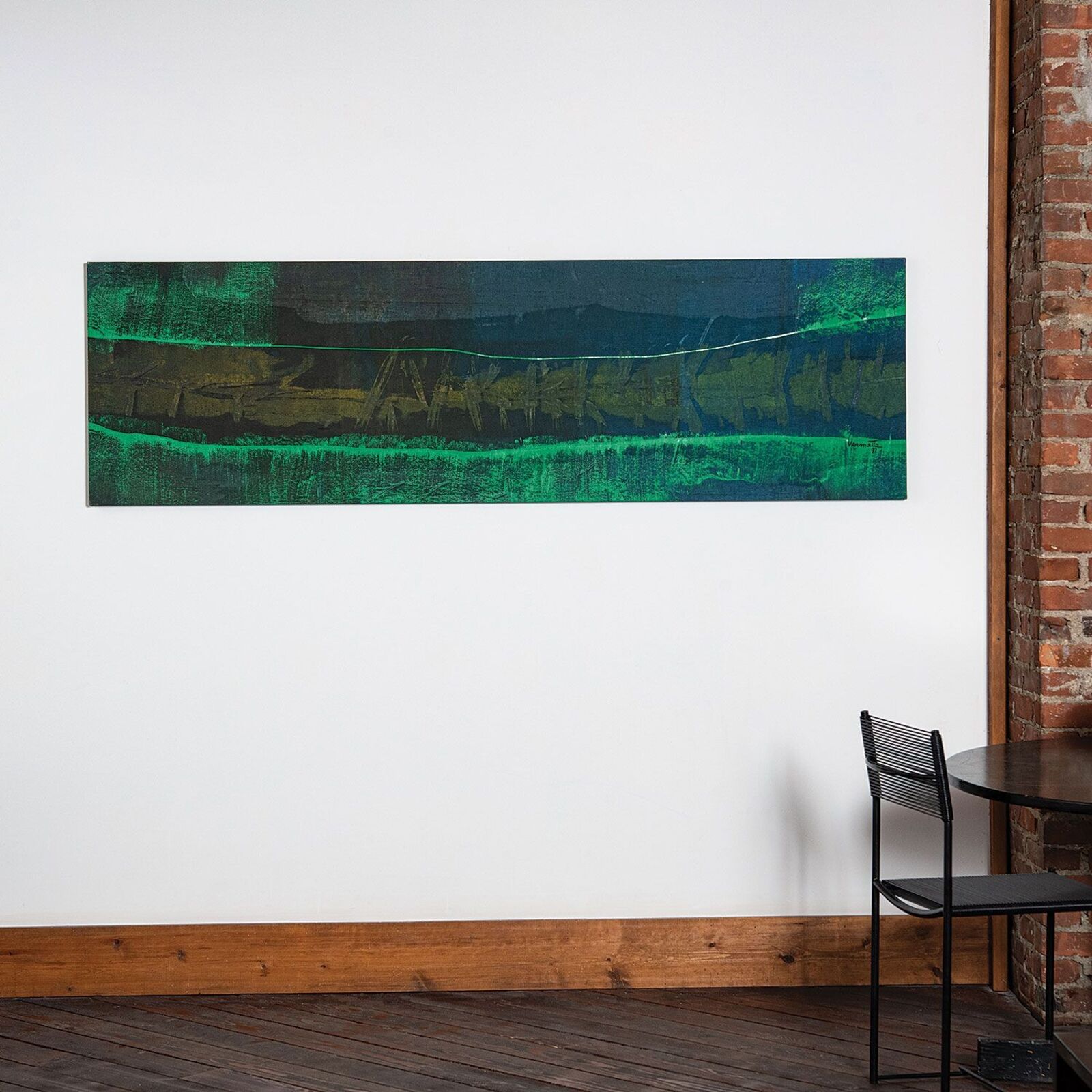 A painting hanging on a wall next to a table and chairs.