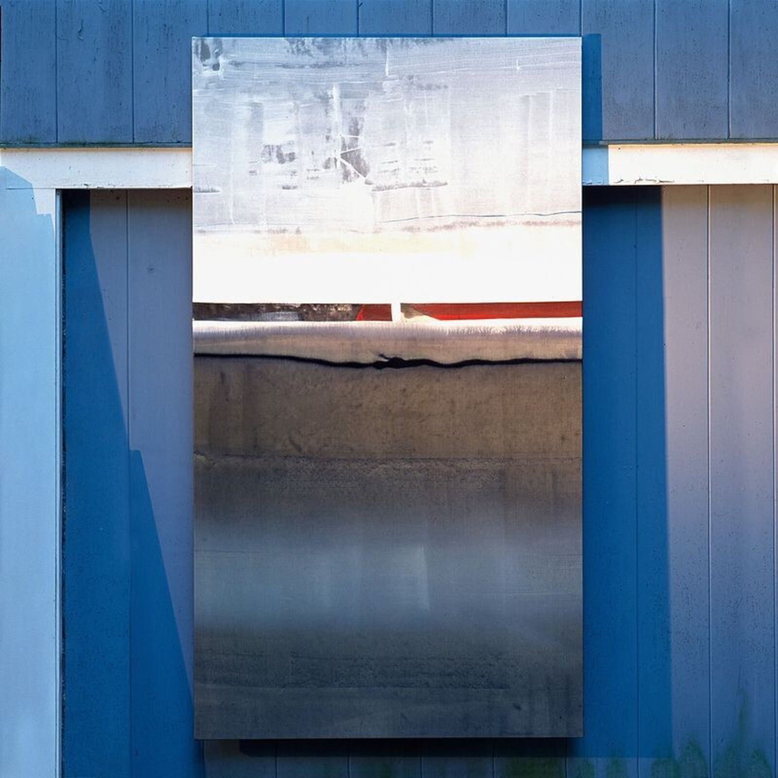 A vertical rectangular artwork featuring layered textures and muted tones within a dark frame.