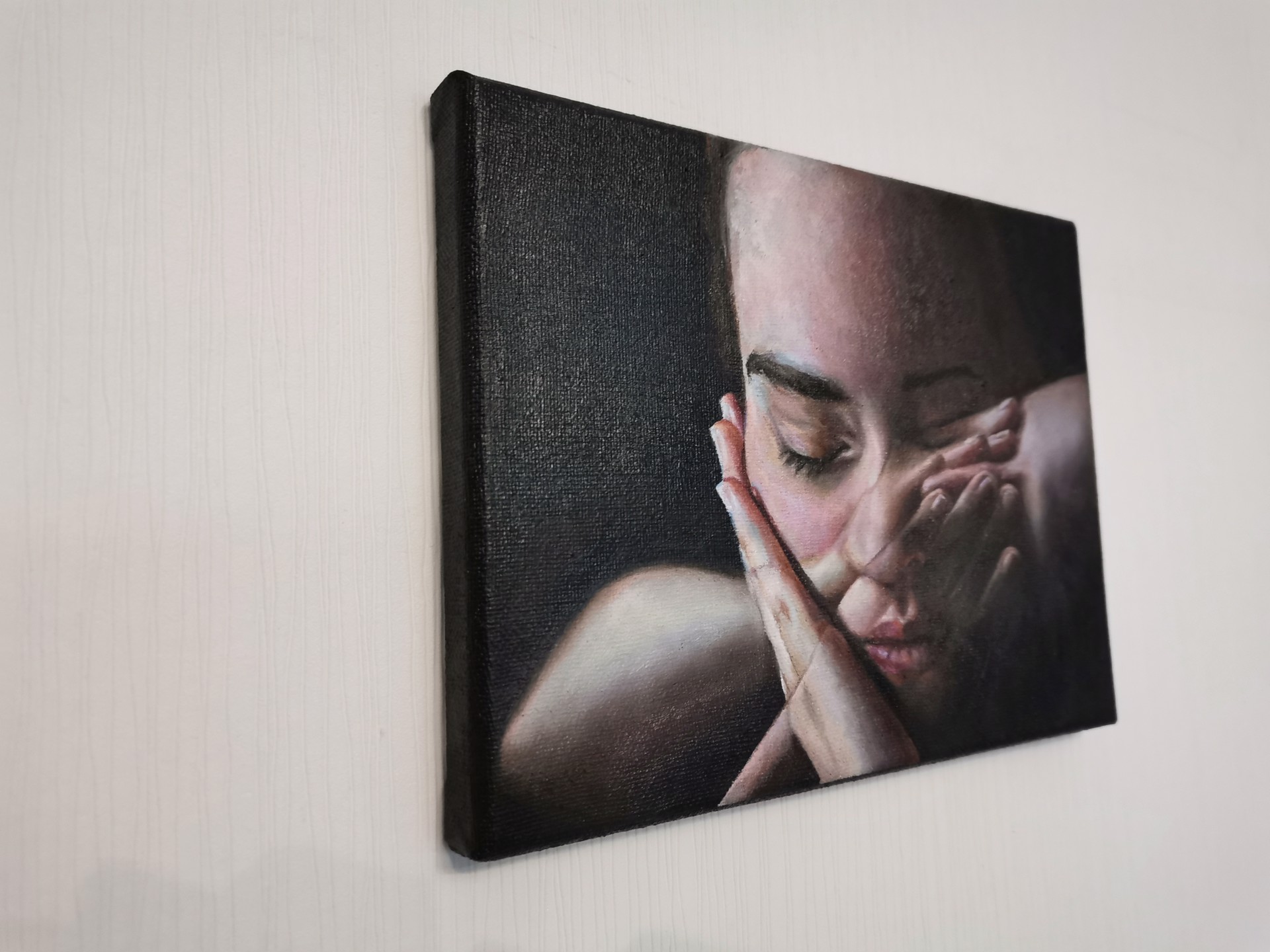 A painting of a woman covering her face with her hands.