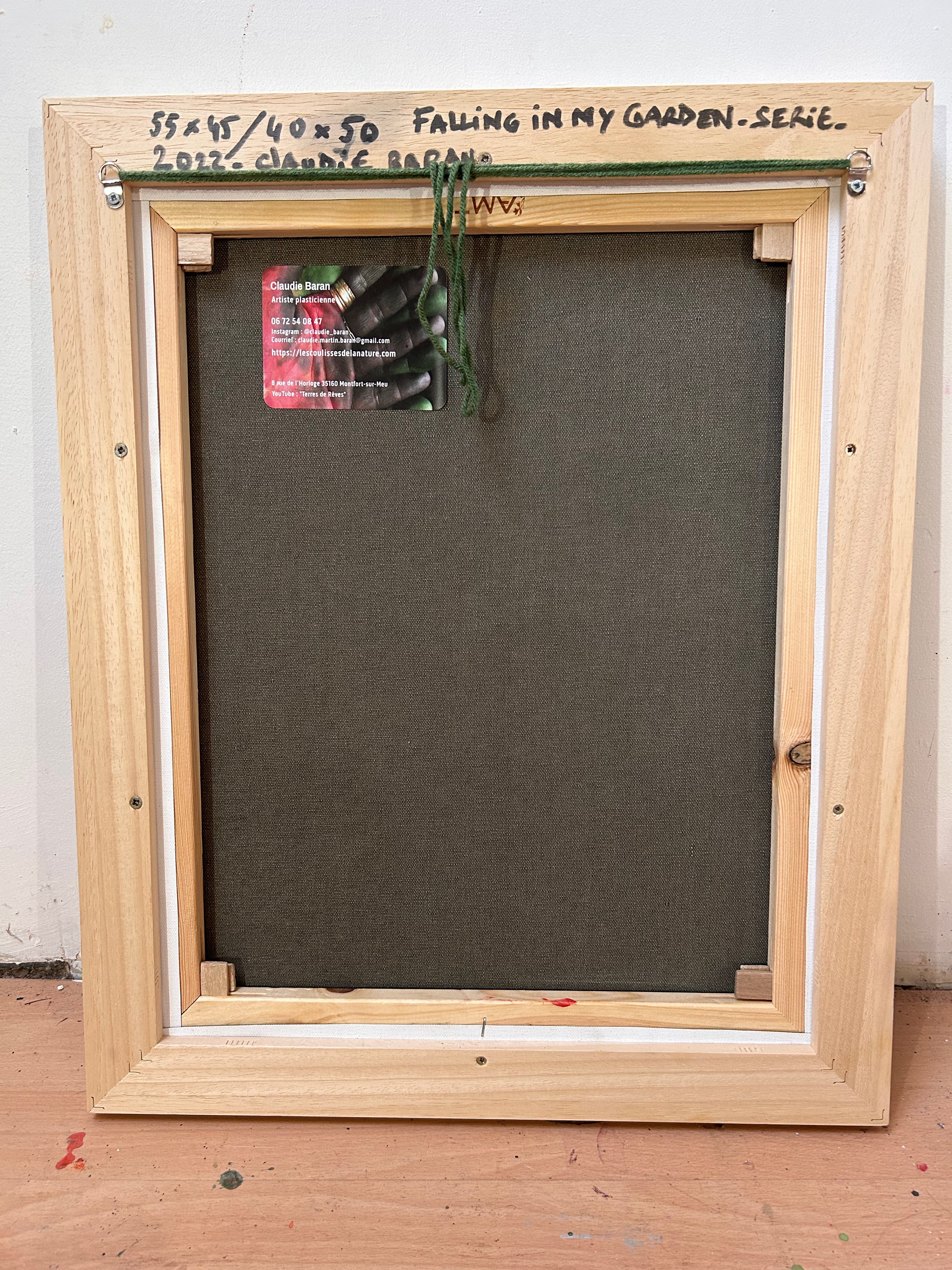 A painting of flowers in a wooden frame on a wall.