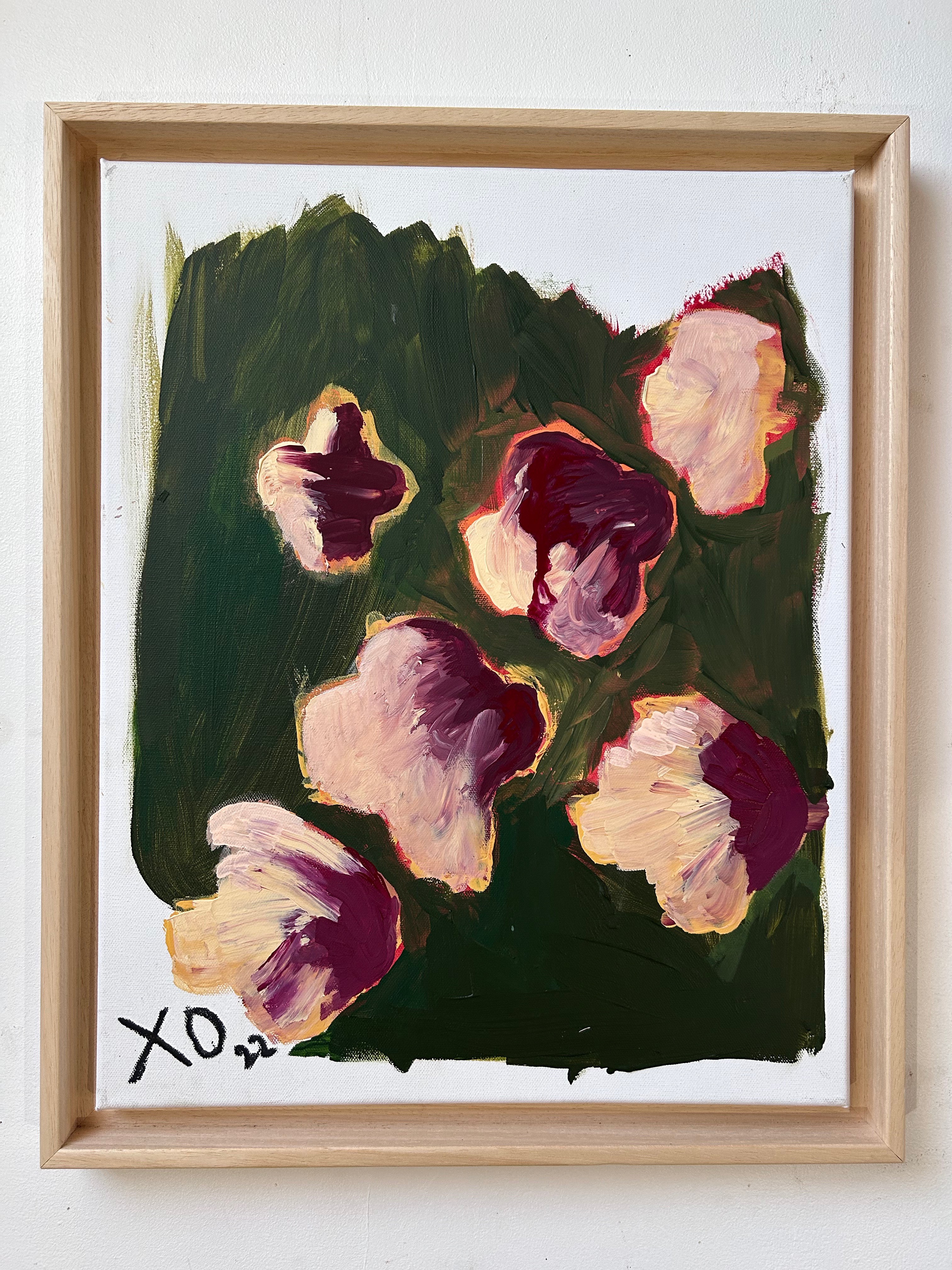 A painting of flowers in a wooden frame on a wall.
