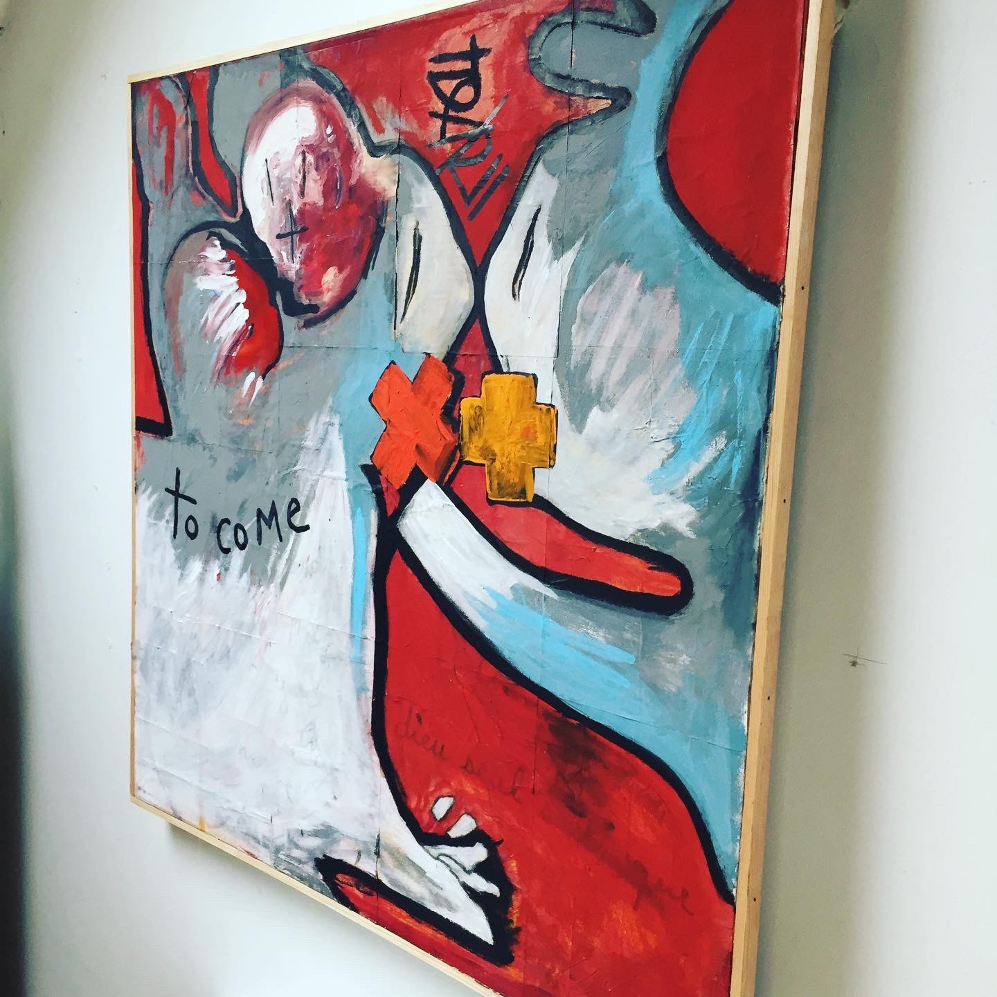 A painting of a woman's face with a yellow cross on it.