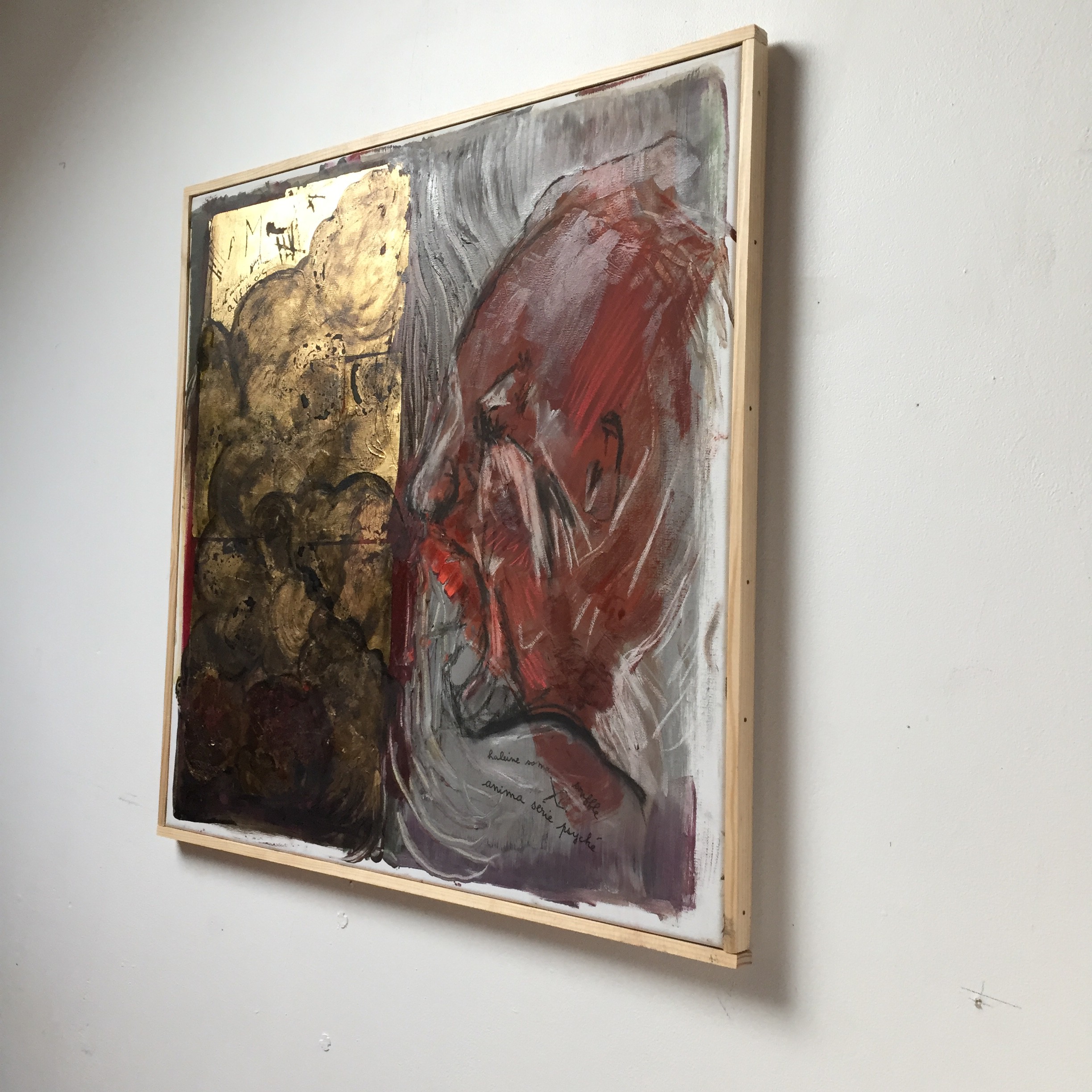 A painting of a woman's face with red and gold paint.
