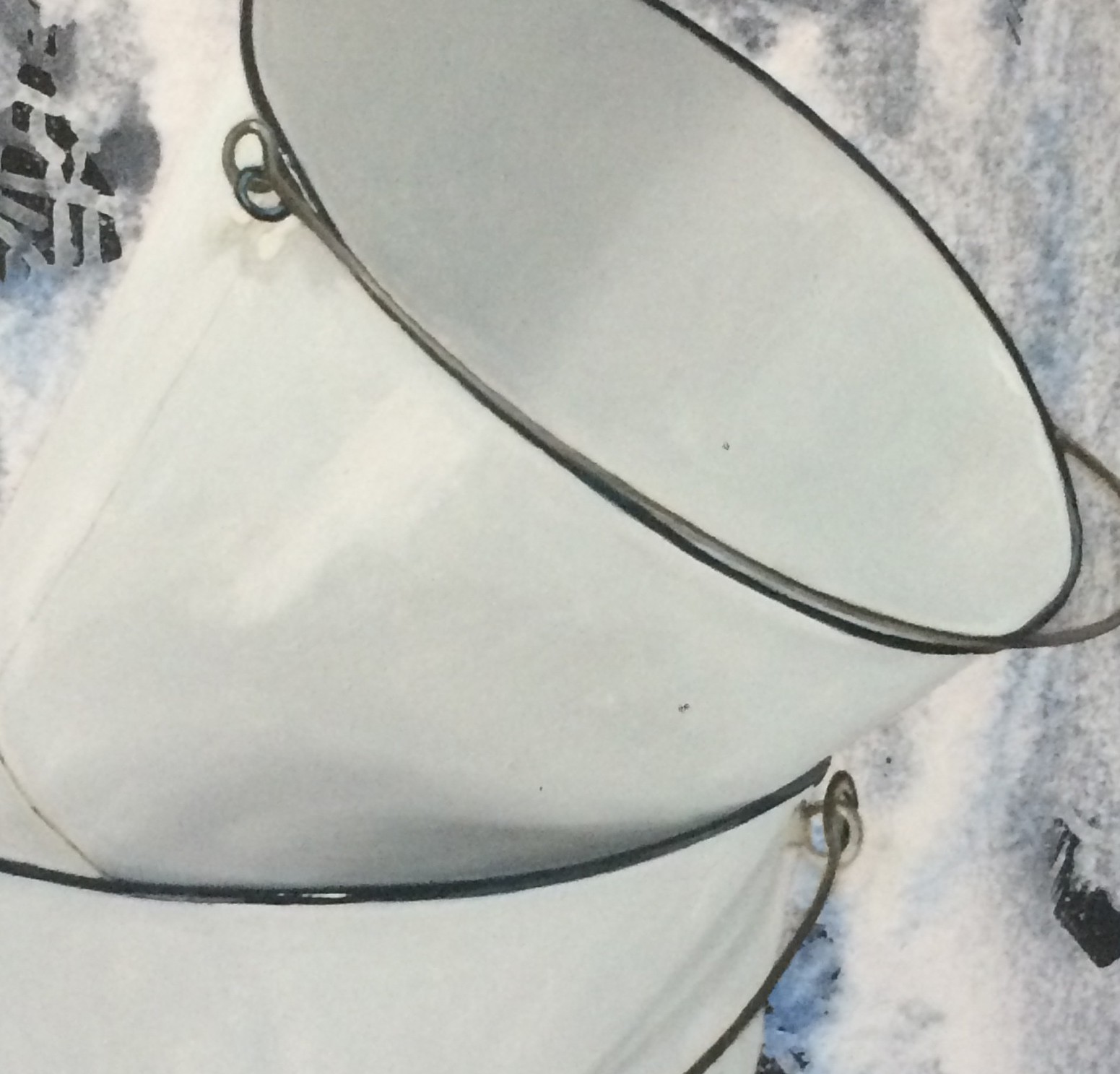 A white bucket sitting on top of a snow covered ground.
