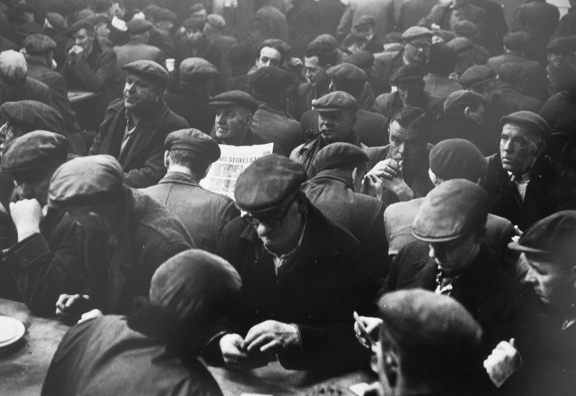 A large group of men sitting around a table eating food.
