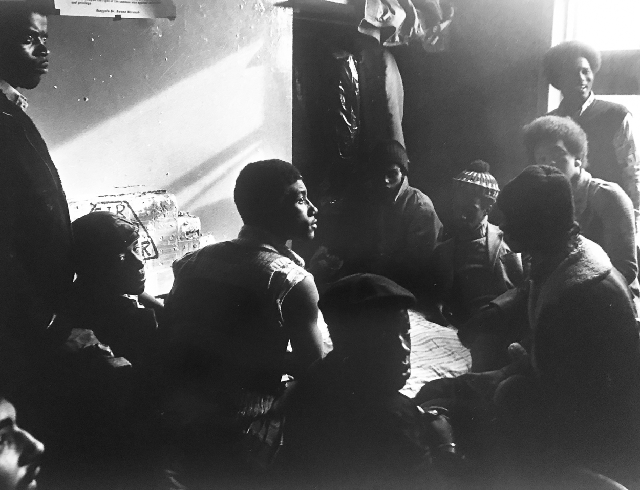 A group of people sitting around each other in a room.