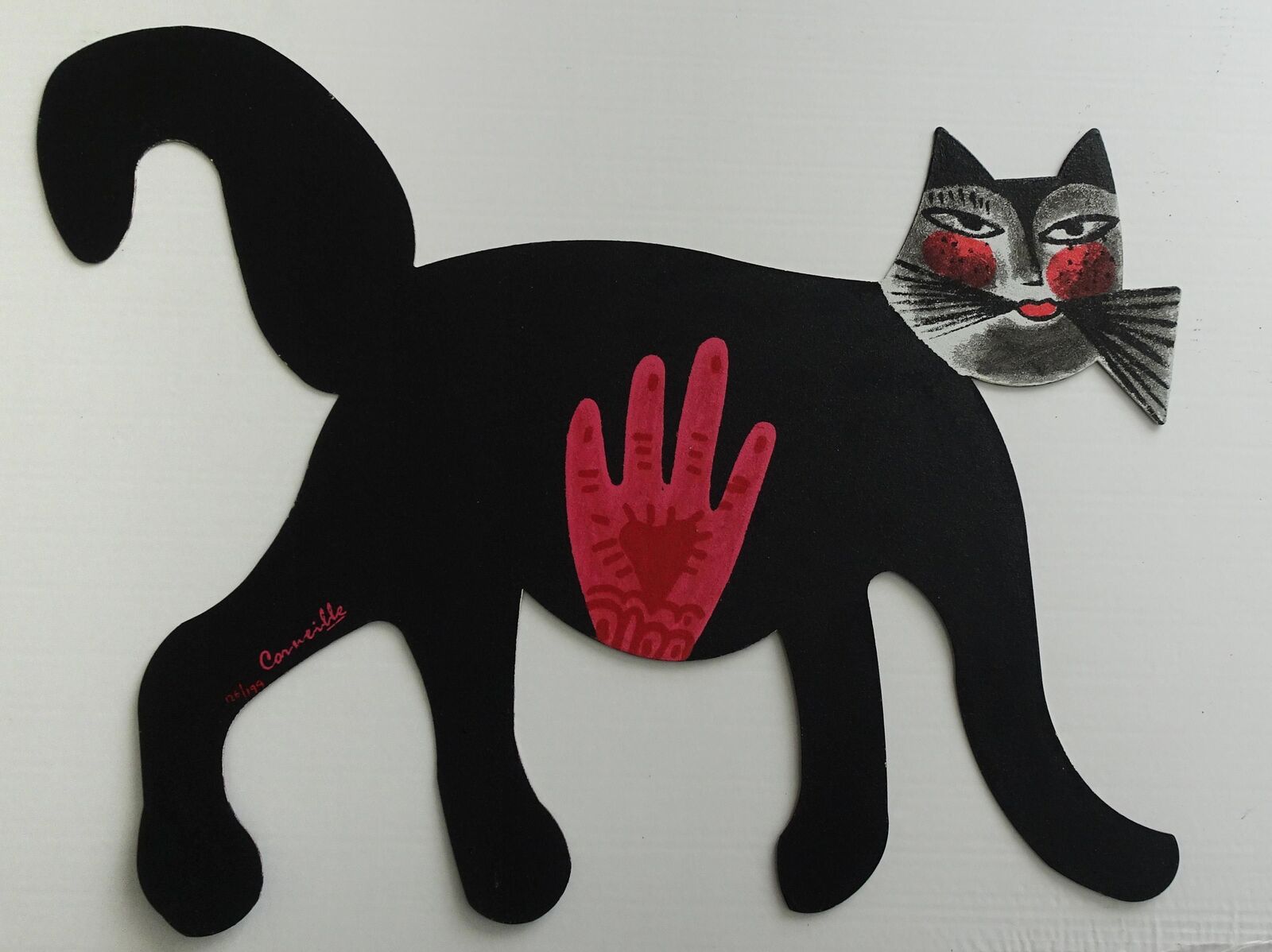 A black cat with a red handprint on it's back.