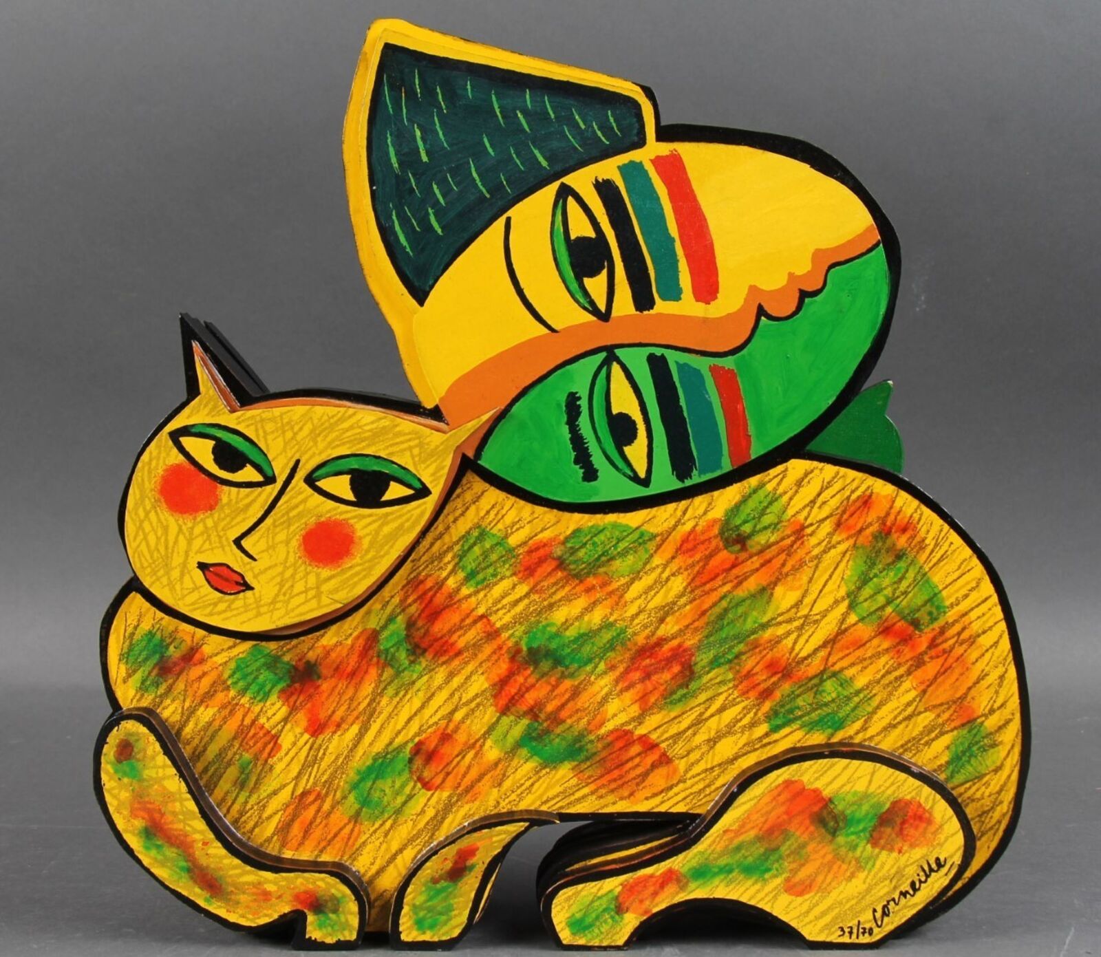 A yellow cat with a green hat on its head.