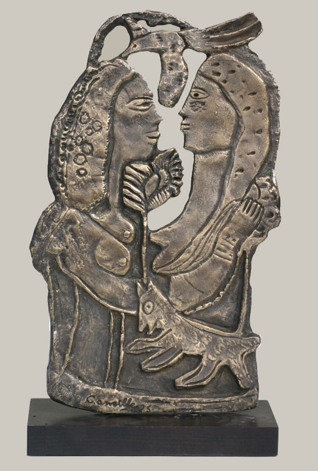 A bronze sculpture of a woman holding a bird in her hand.