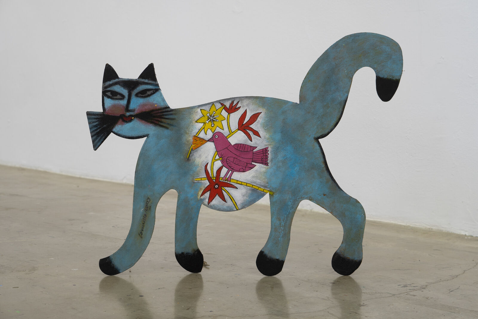 A blue cat with a bird on its back.