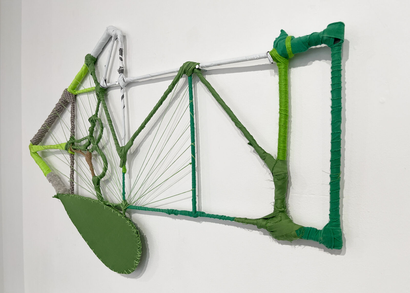 A wireframe sculpture of a biplane constructed from wrapped rods and string.