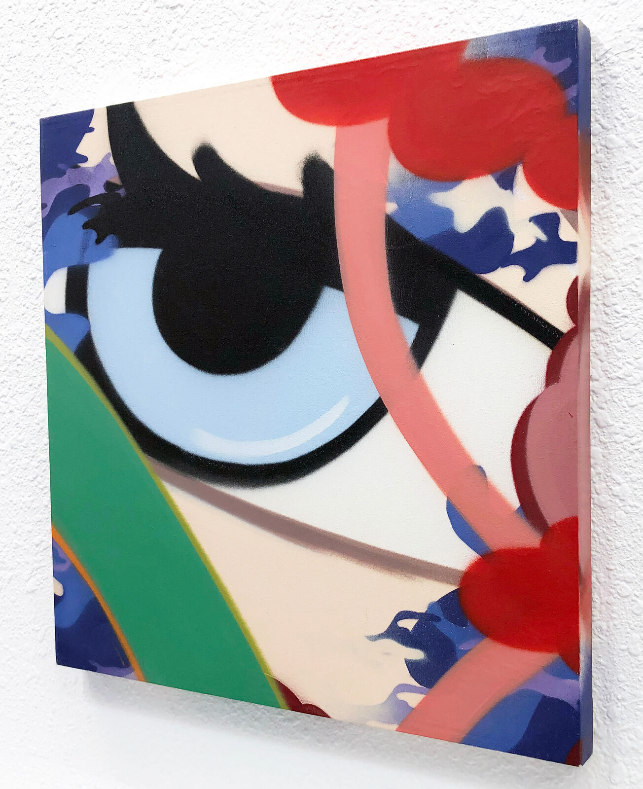 A painting of an eye on a white wall.