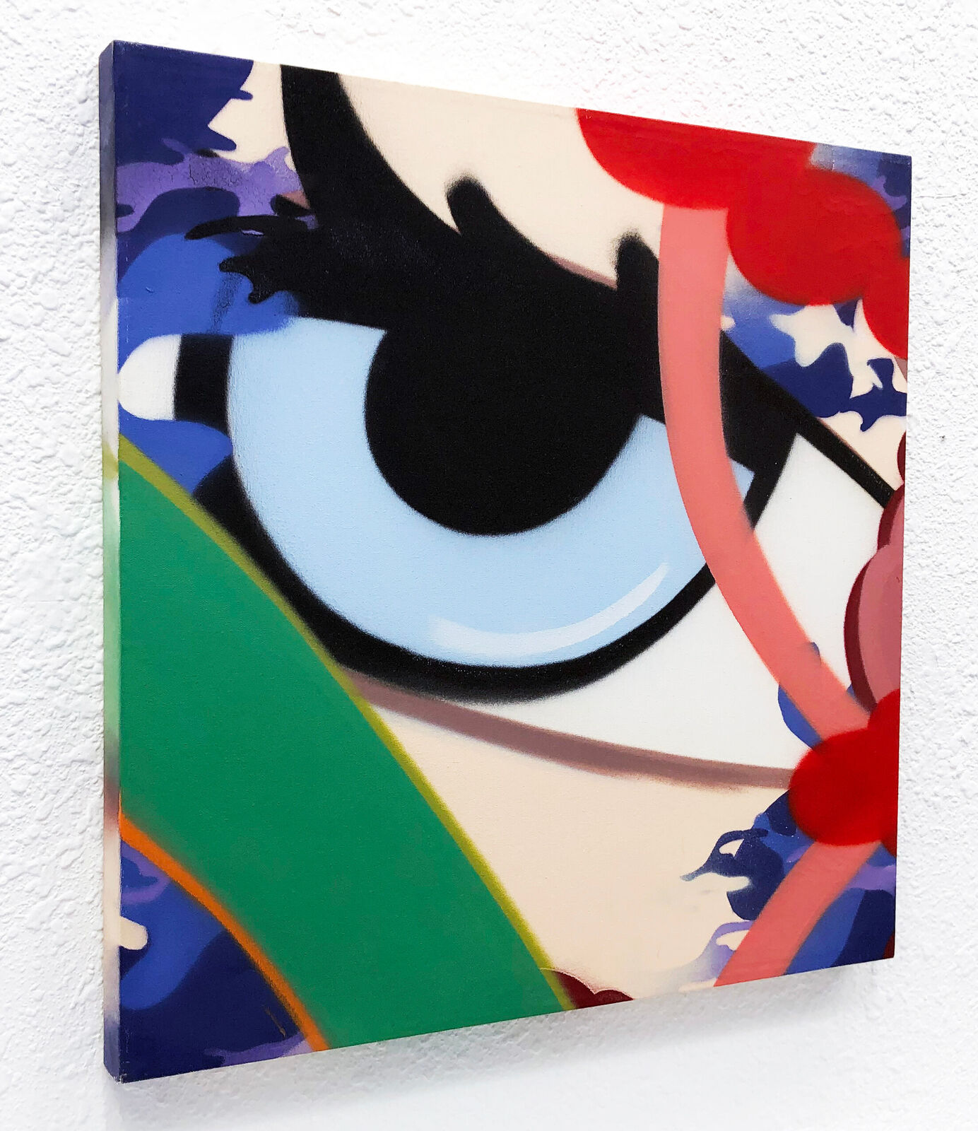 A painting of an eye on a white wall.