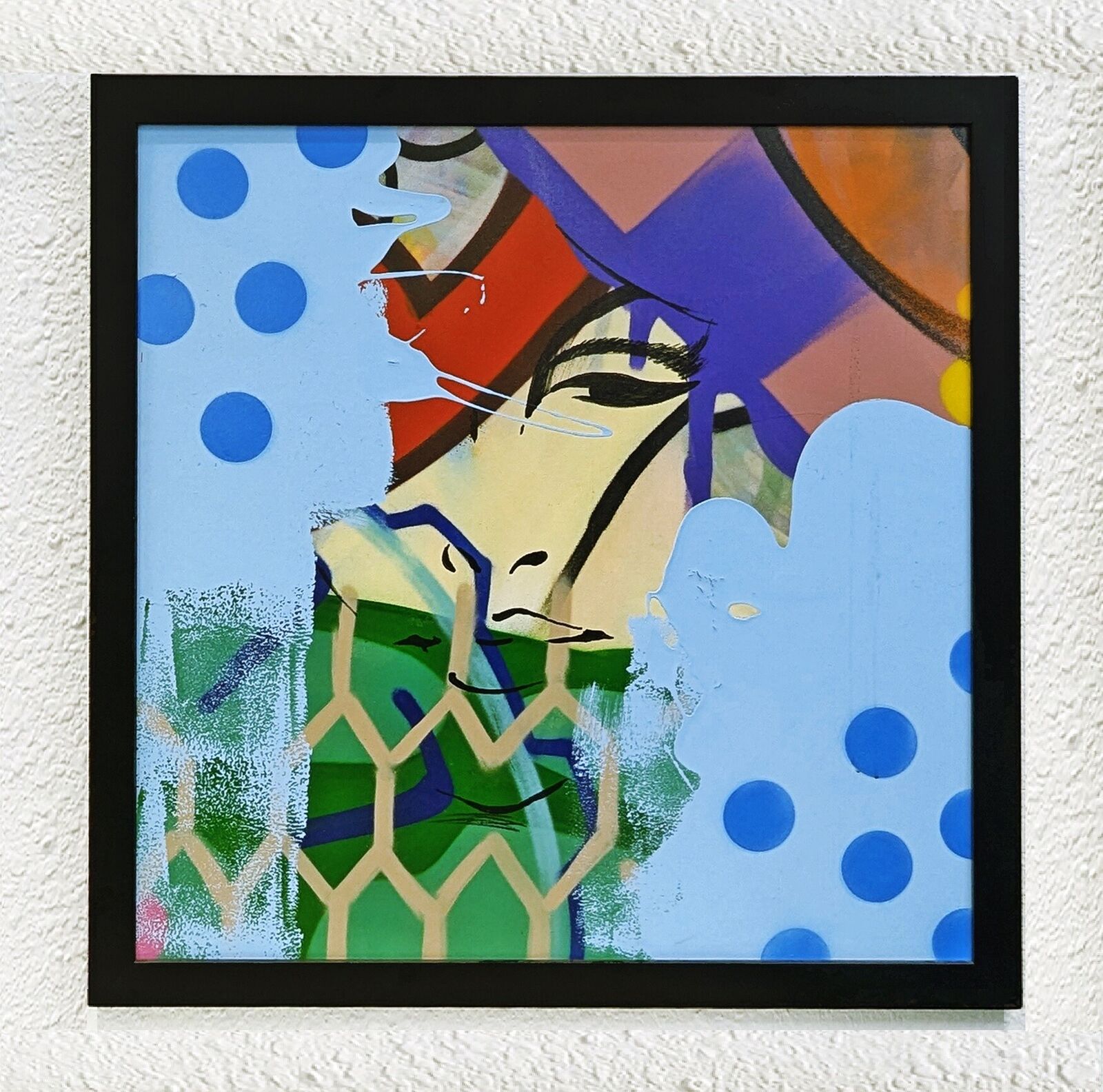 A painting of a woman's face on a wall.