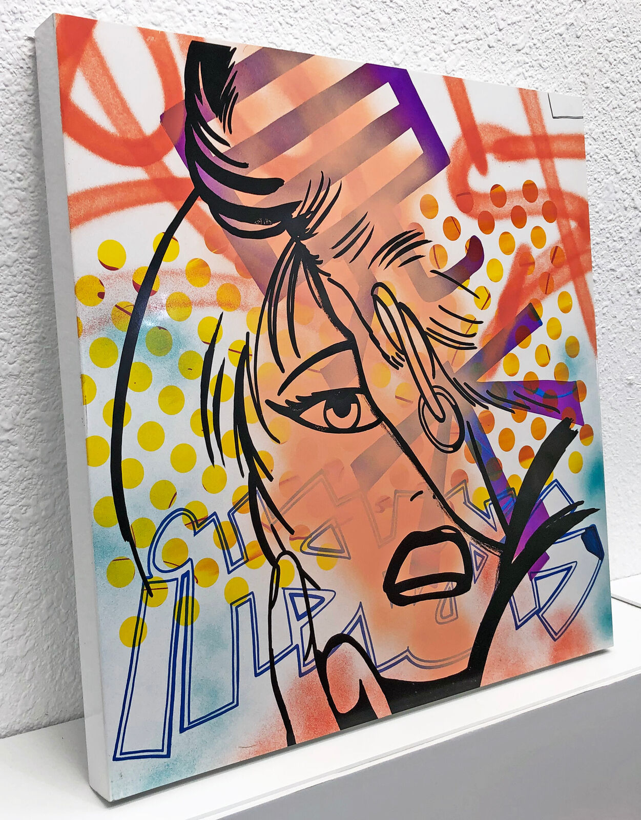 A painting of a woman's face on a wall.