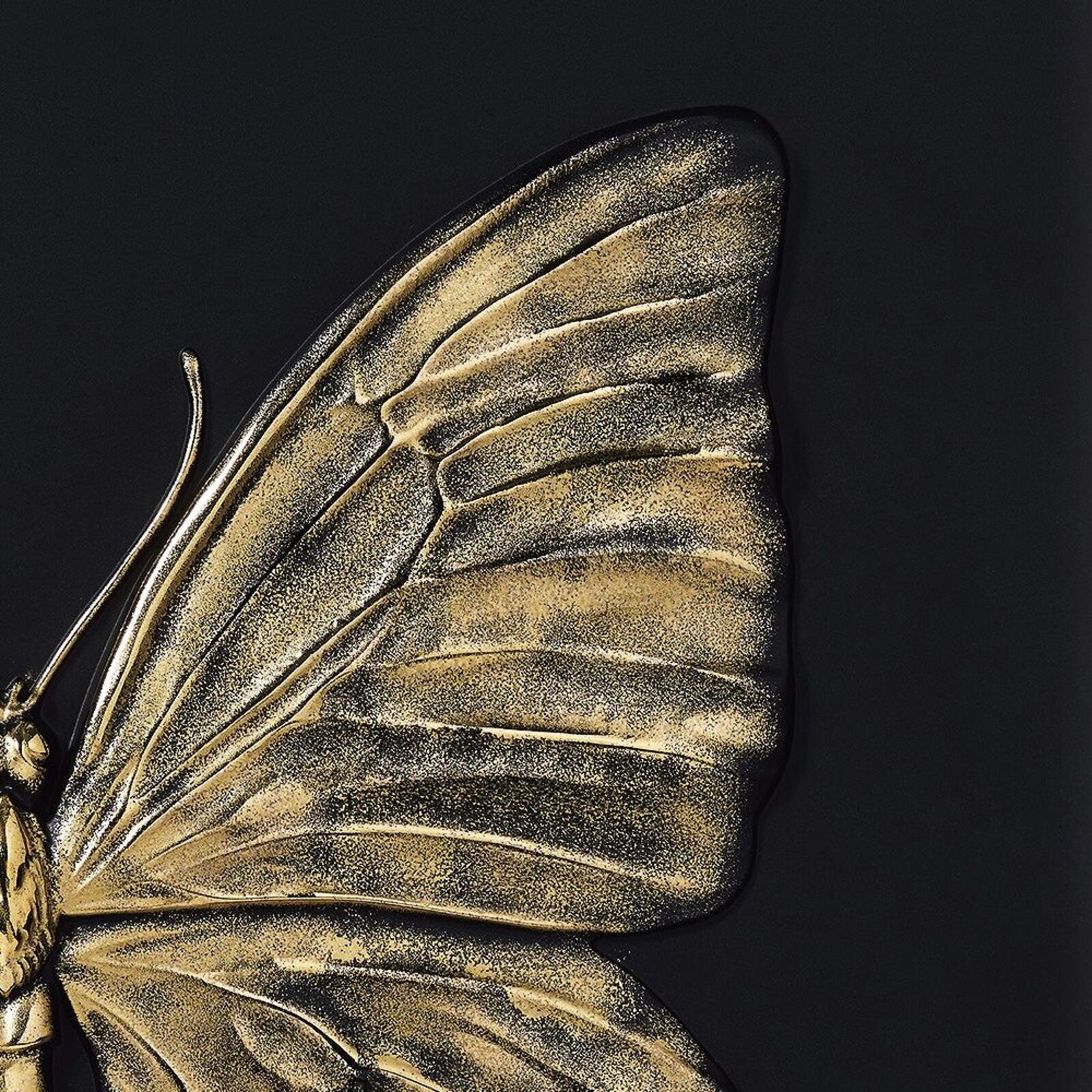 A gold butterfly on a black background. 