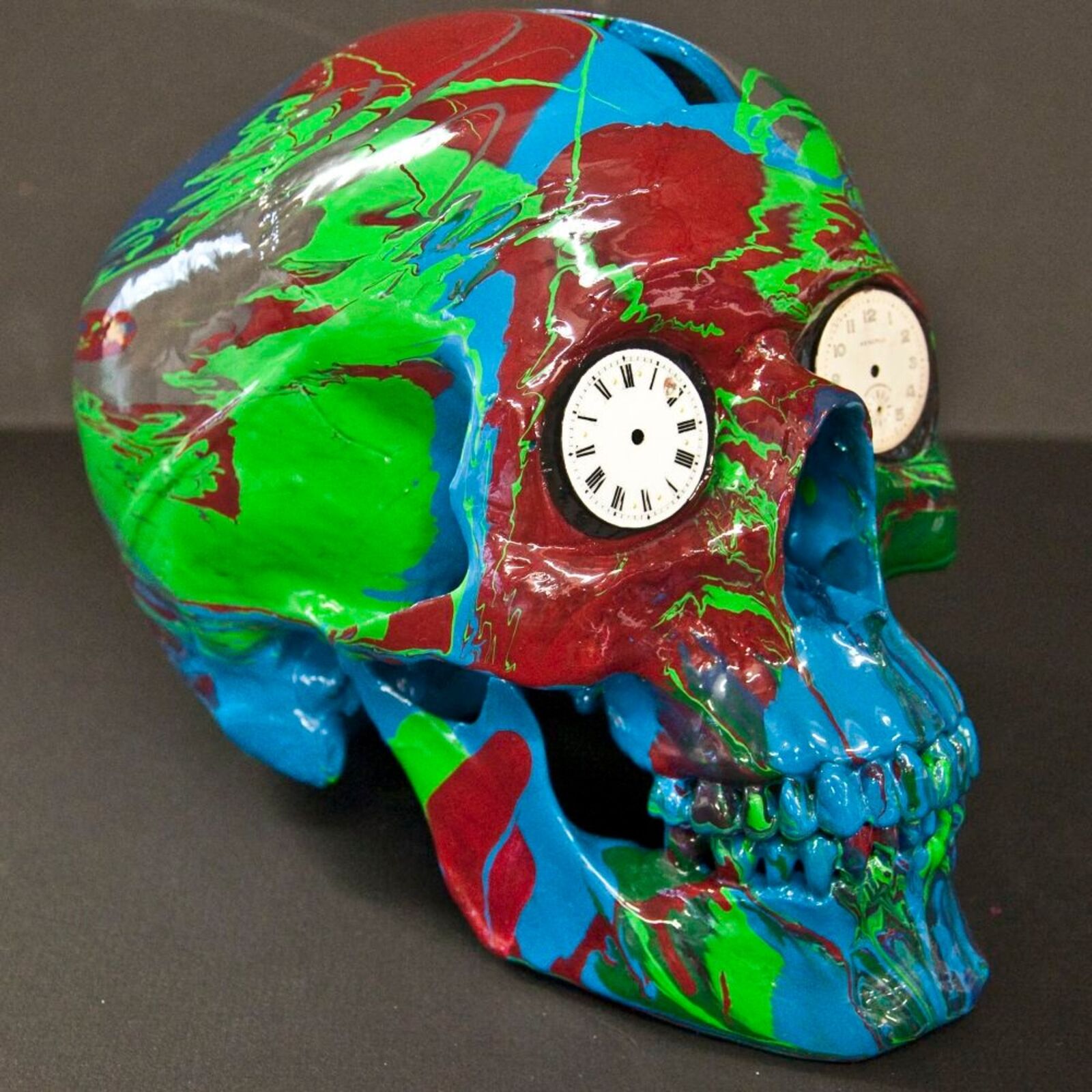 A colorful skull with a clock on top of it.