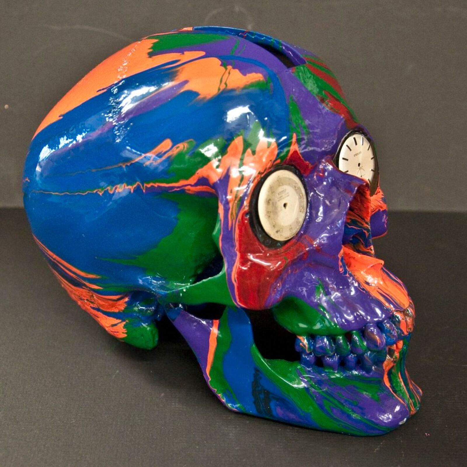 A colorful skull with a clock on top of it.