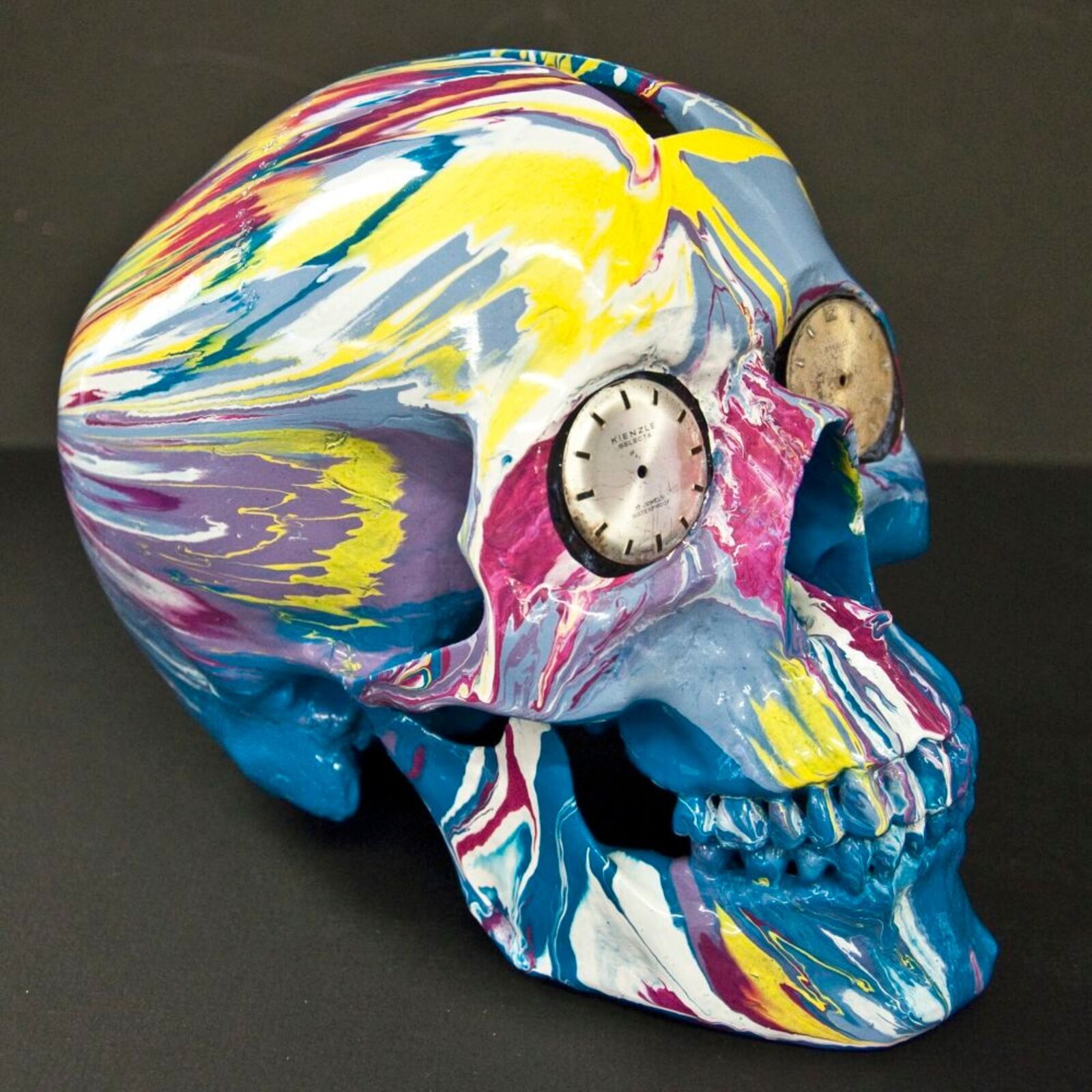 A colorful skull with a clock on top of it.