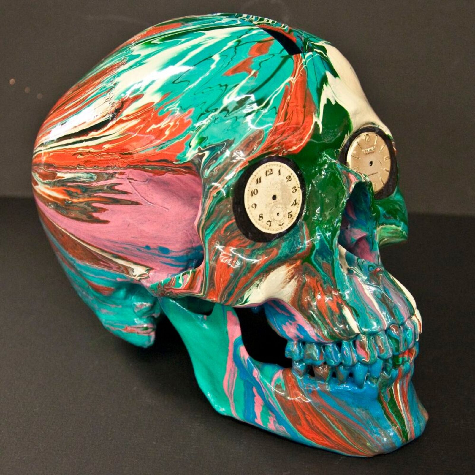 A colorful skull with a clock on top of it.