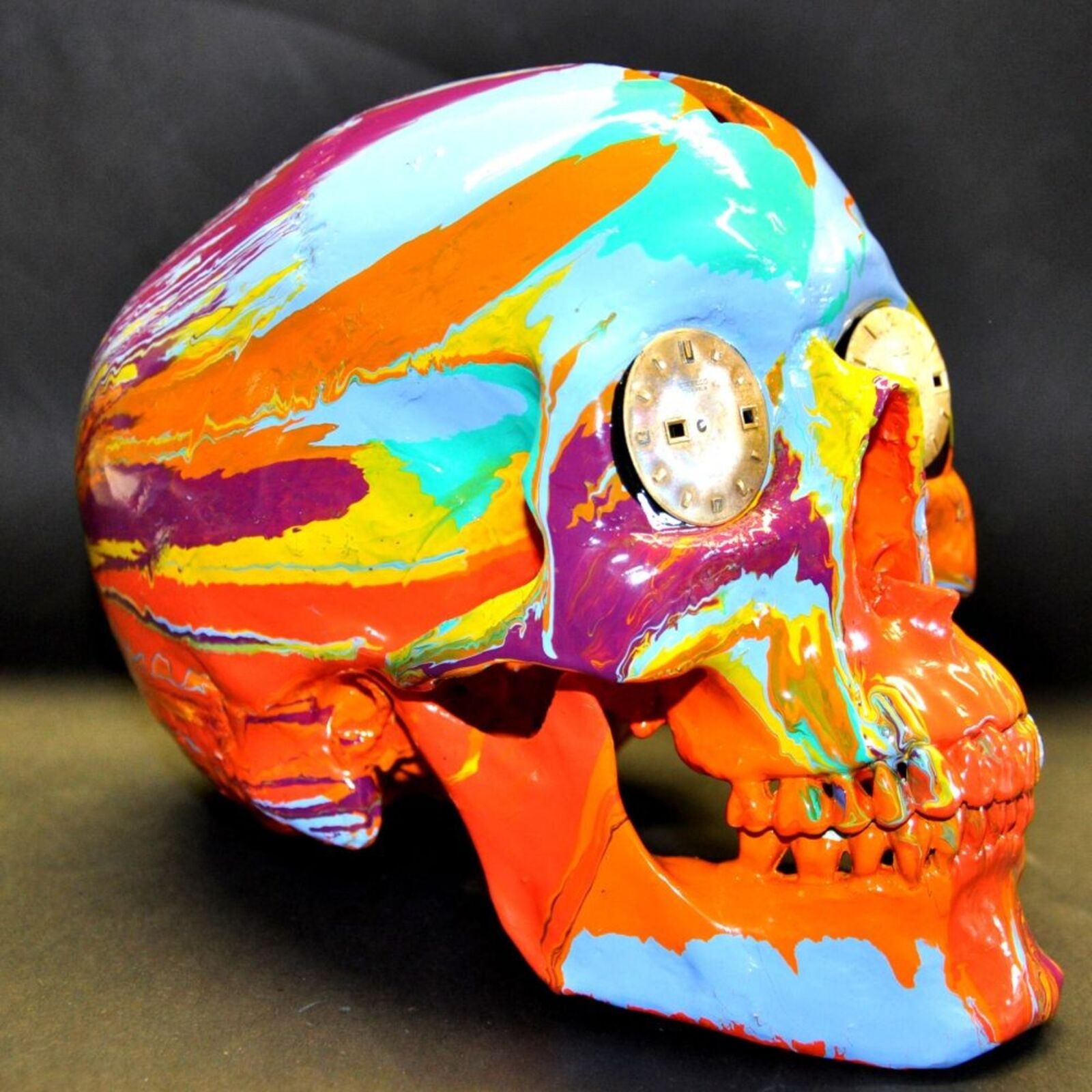 A colorful skull with a clock on top of it.
