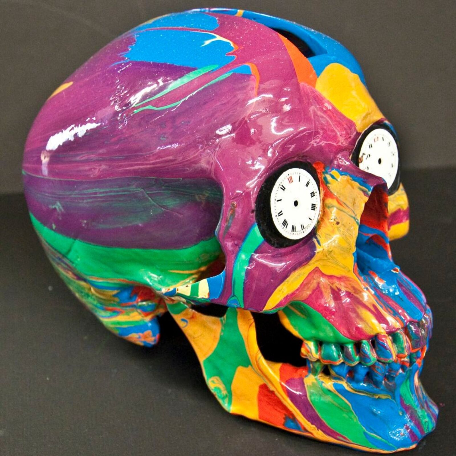 A colorful skull with a clock on top of it.