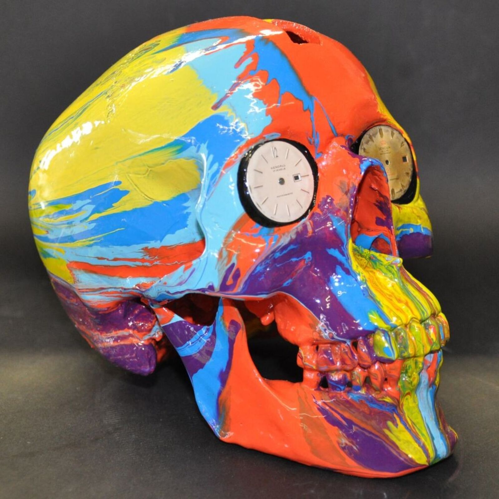 A colorful skull with a clock on top of it.