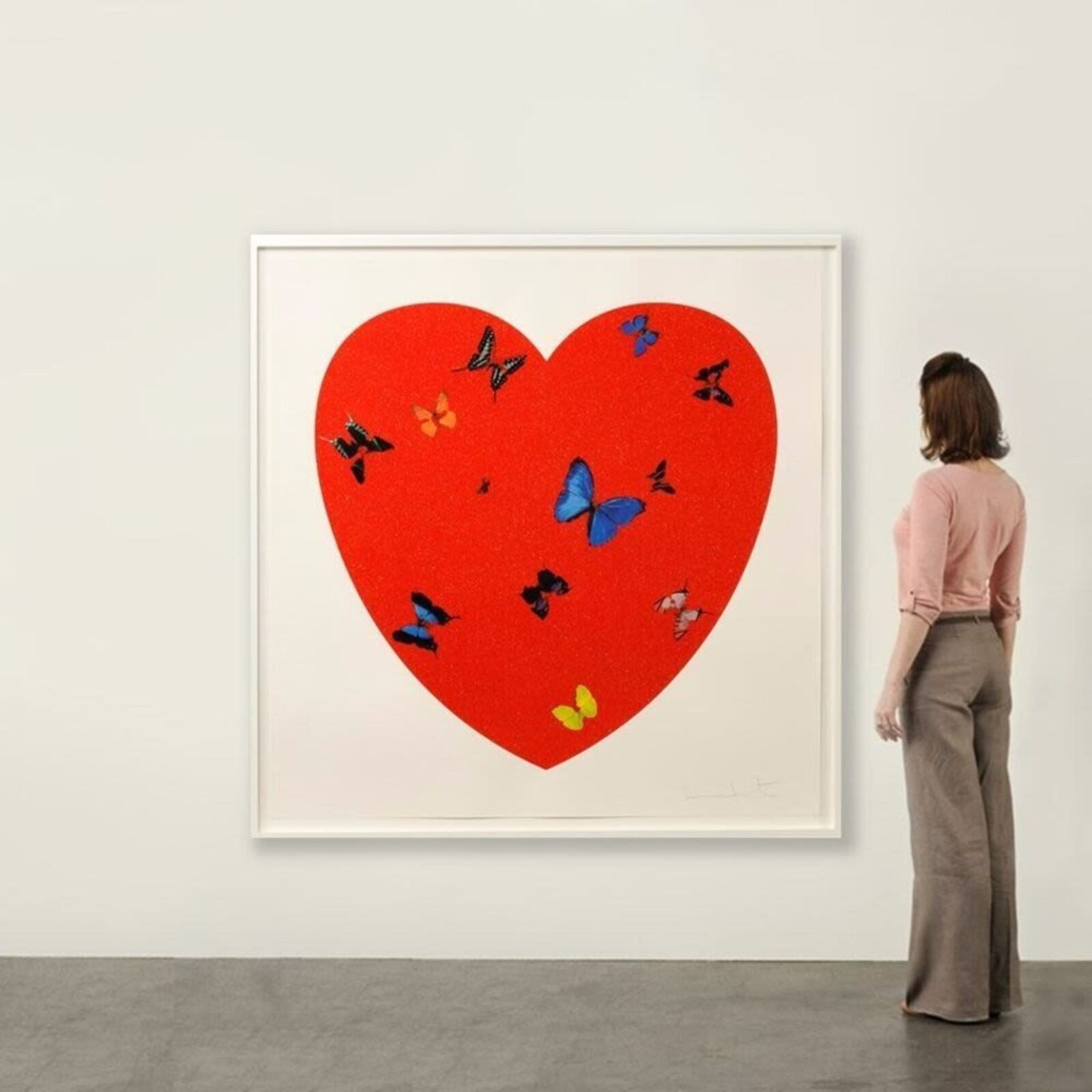 A red heart with butterflies flying around it.