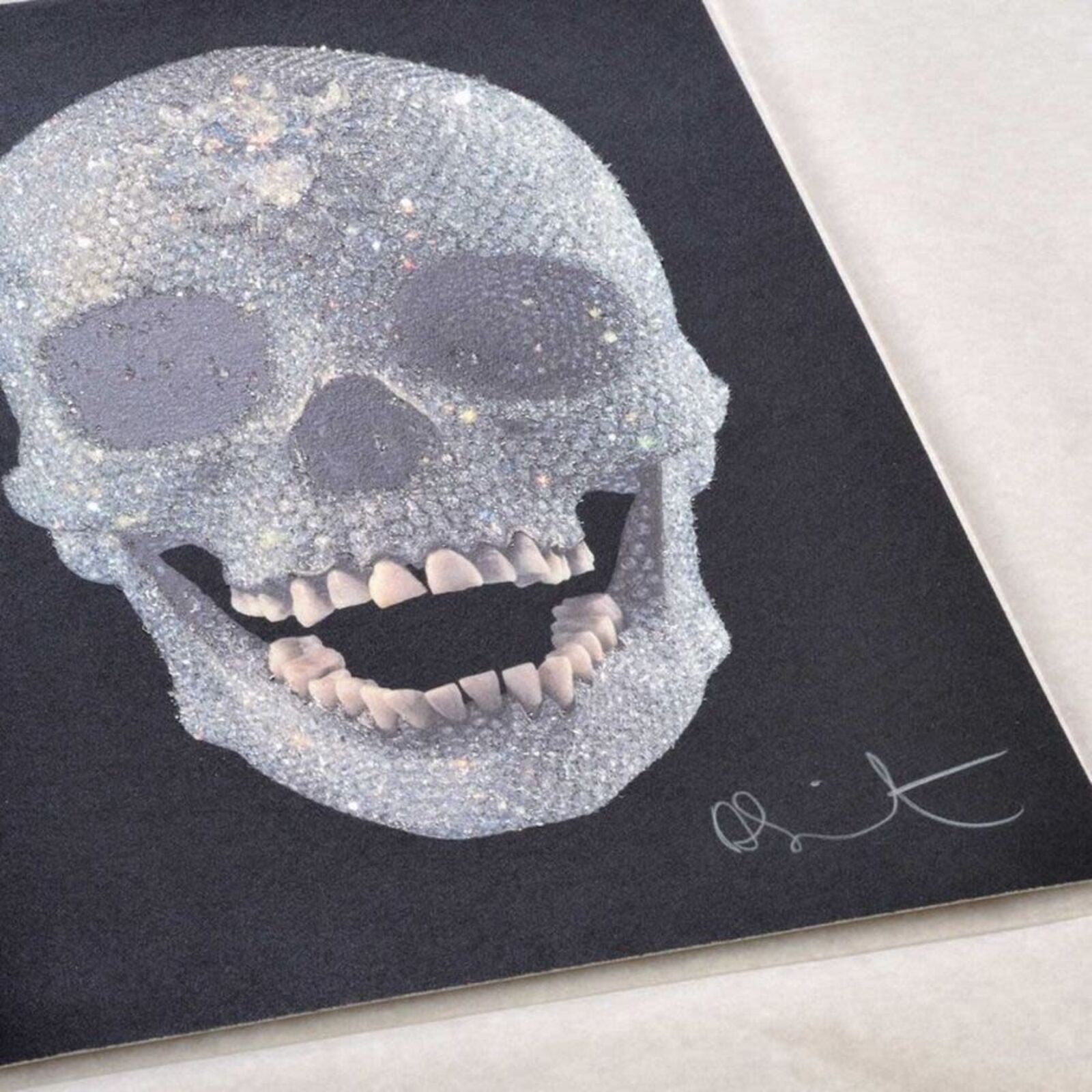 A framed picture of a skull with a diamond on it.