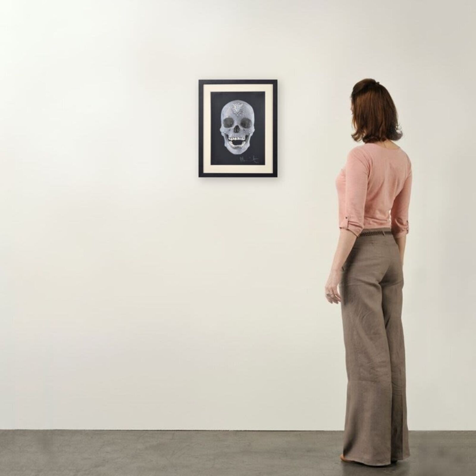A framed picture of a skull with a diamond on it.