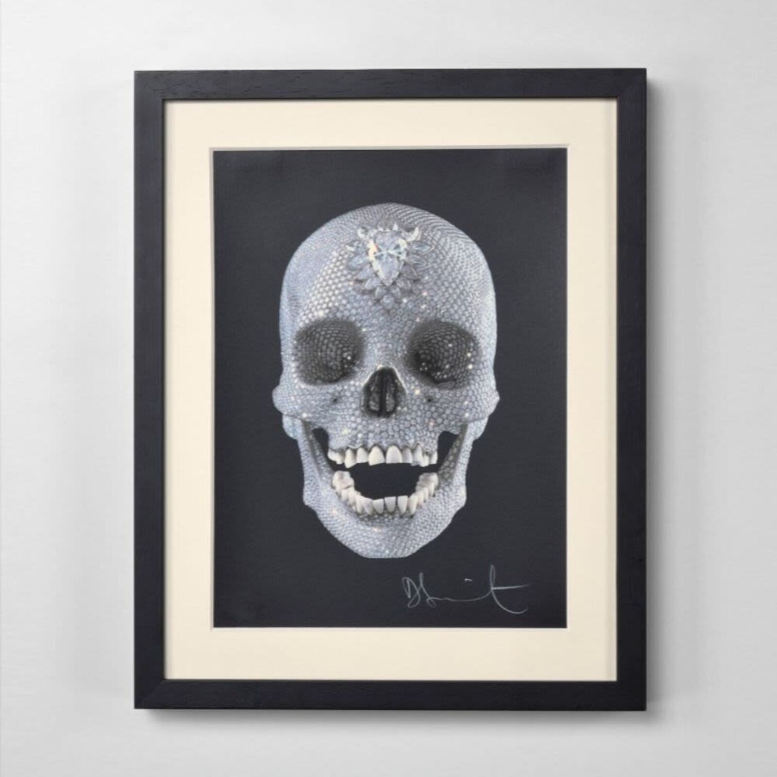 A framed picture of a skull with a diamond on it.