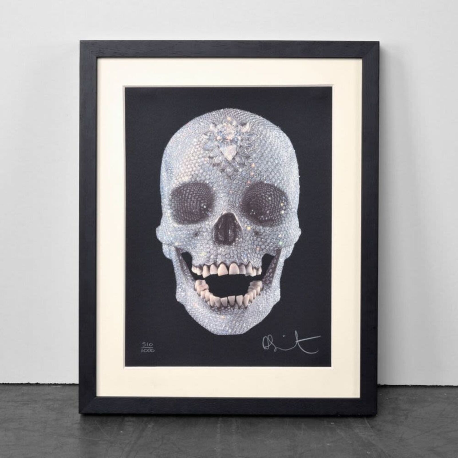 A framed picture of a skull with a diamond on it.