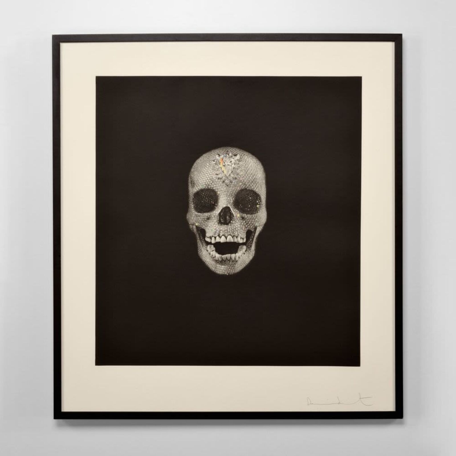 A black and white drawing of a skull on a wall.