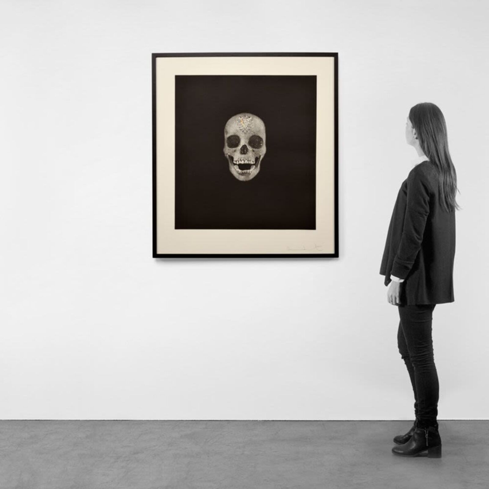 A black and white drawing of a skull on a wall.