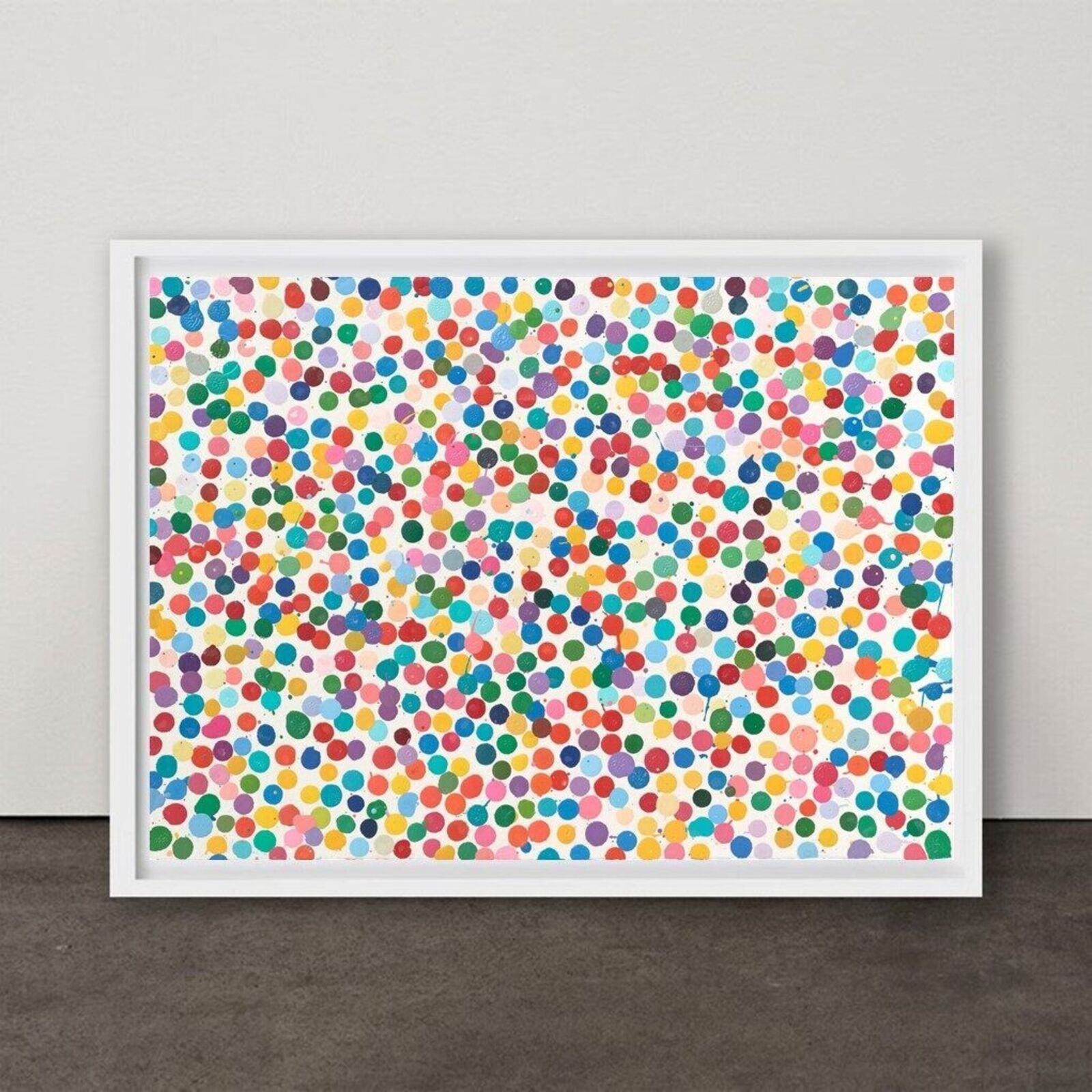 A colorful abstract print filled with multicolored dots in a white frame.