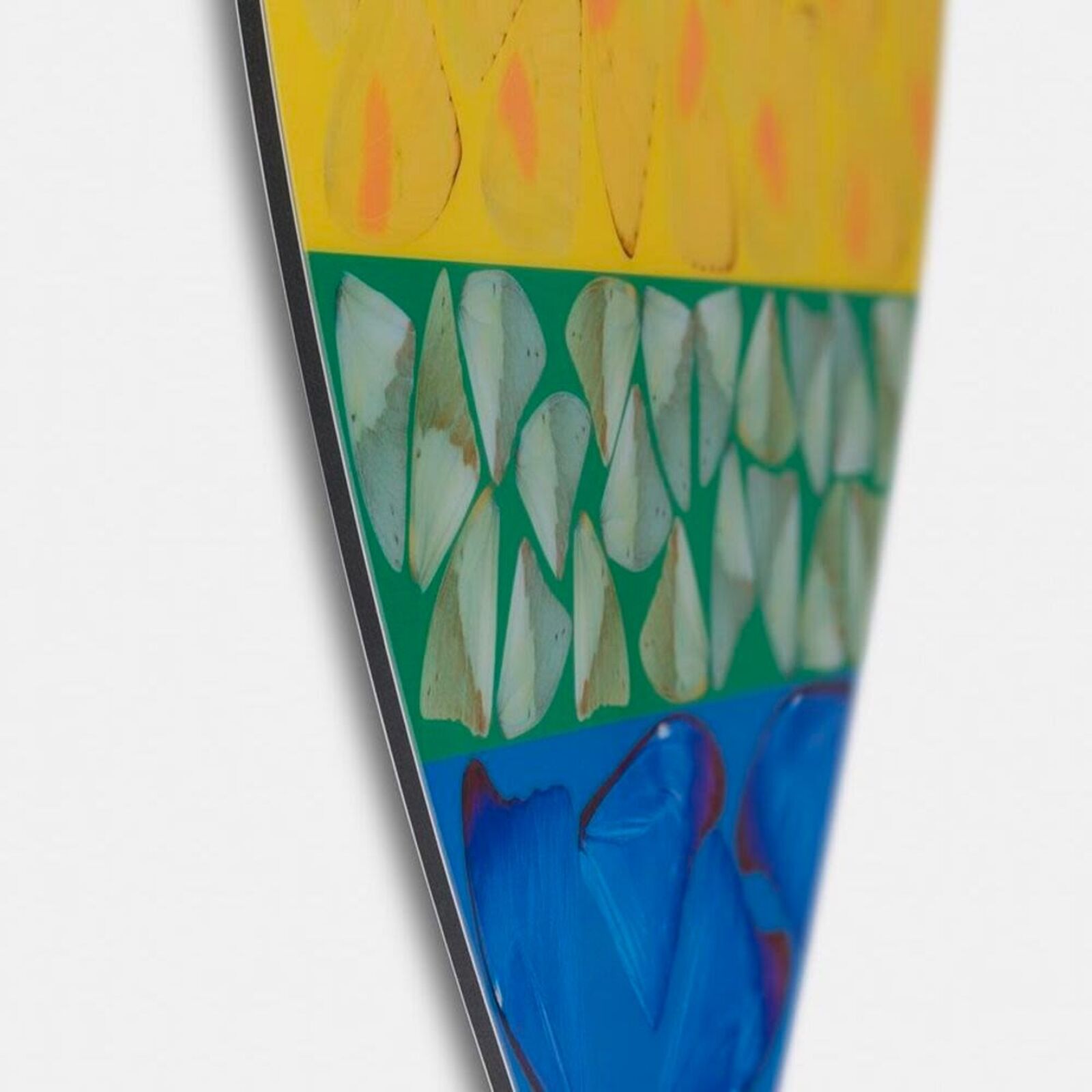 A rainbow colored heart shaped piece of art on a white background.