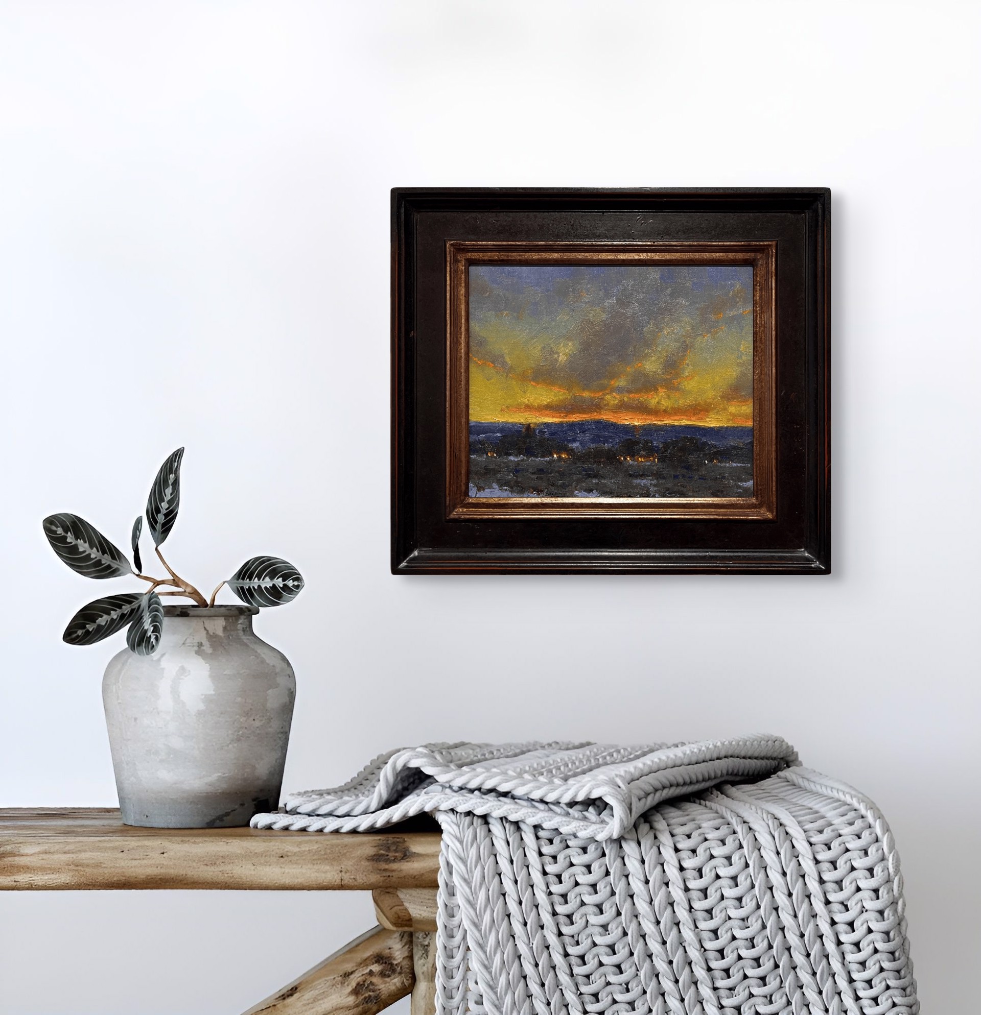 A dramatic landscape painting capturing a twilight sky over a dark, snowy foreground.