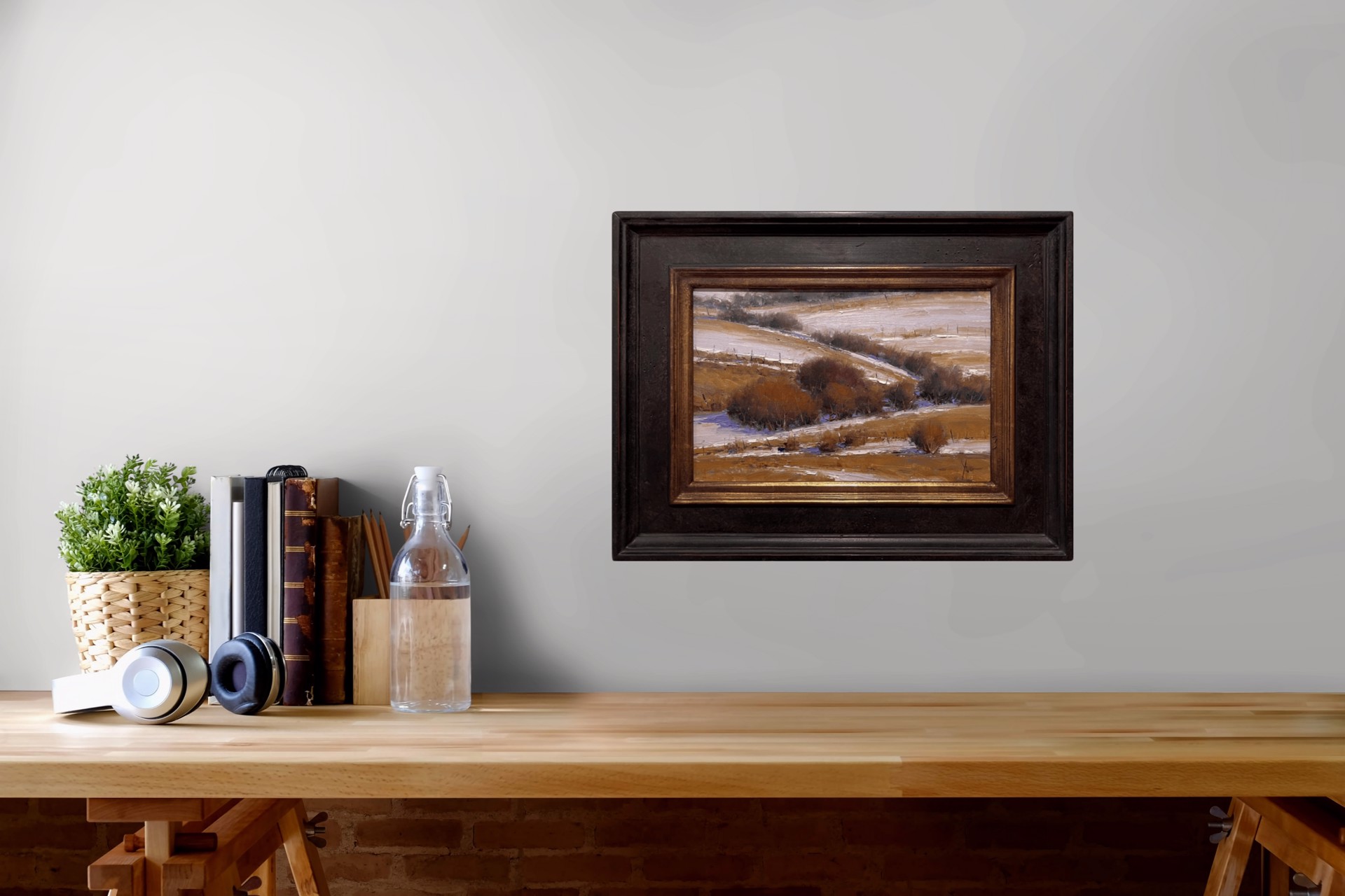 A winter landscape painting featuring snow-covered hills and dark shrubs.