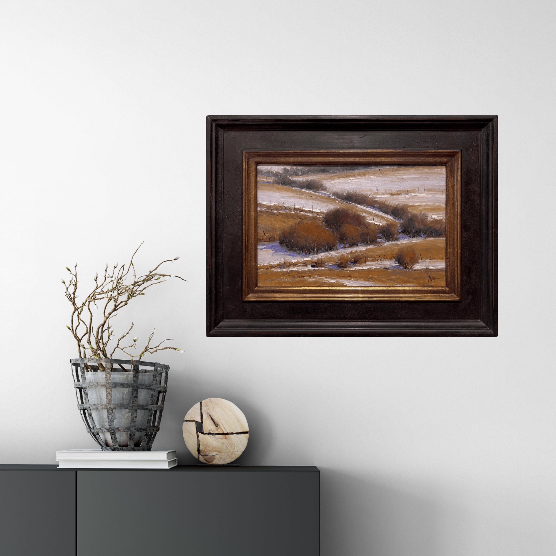 A winter landscape painting featuring snow-covered hills and dark shrubs.