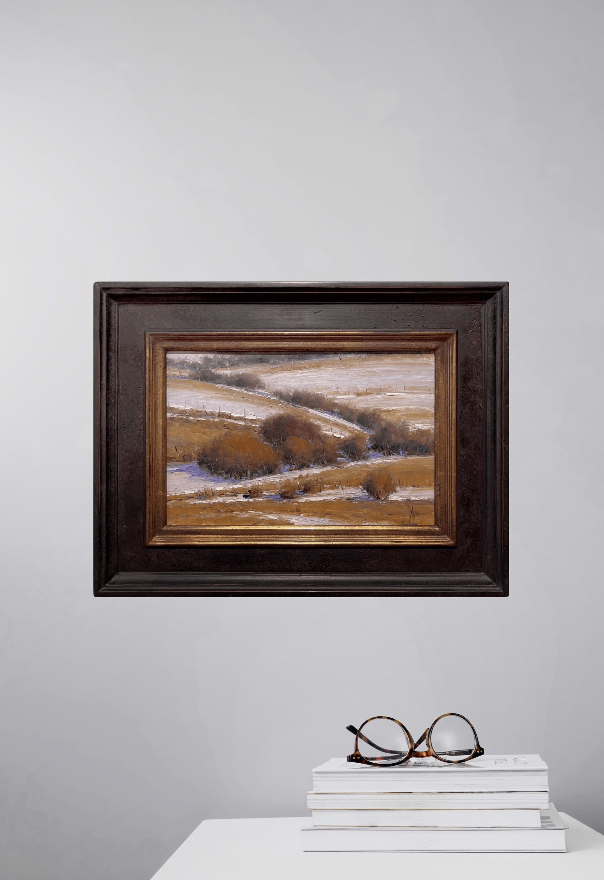 A winter landscape painting featuring snow-covered hills and dark shrubs.