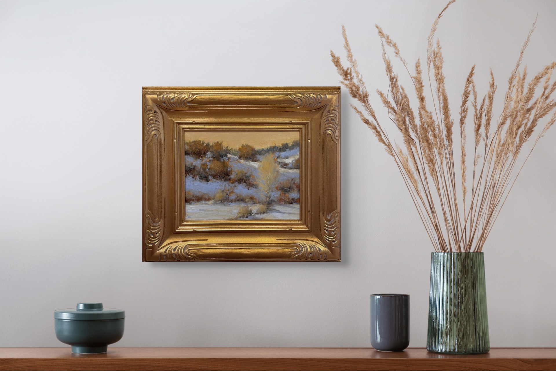 A winter landscape painting capturing a snowy hillside under a warm, golden sky.