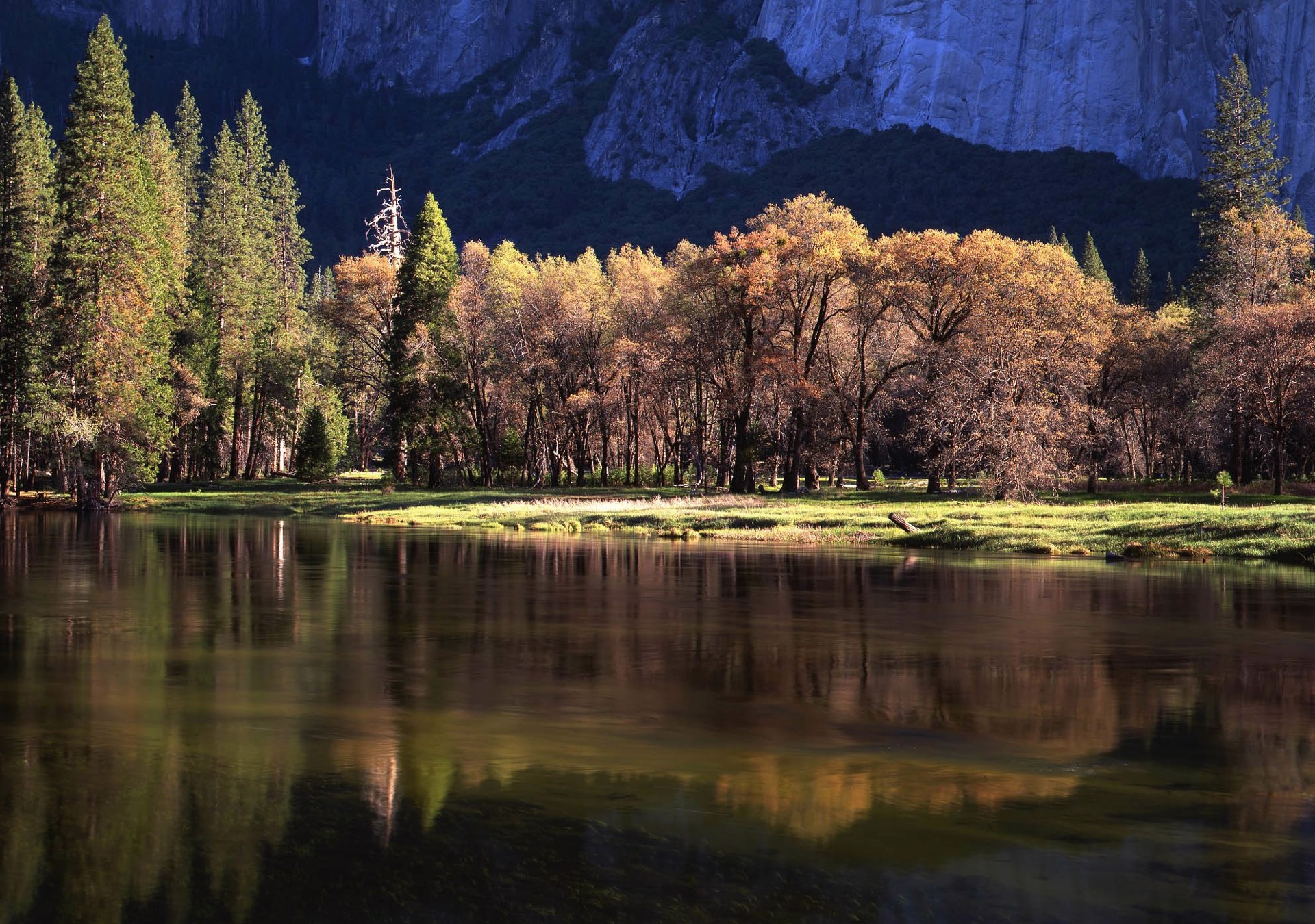 A body of water surrounded by trees and mountains.