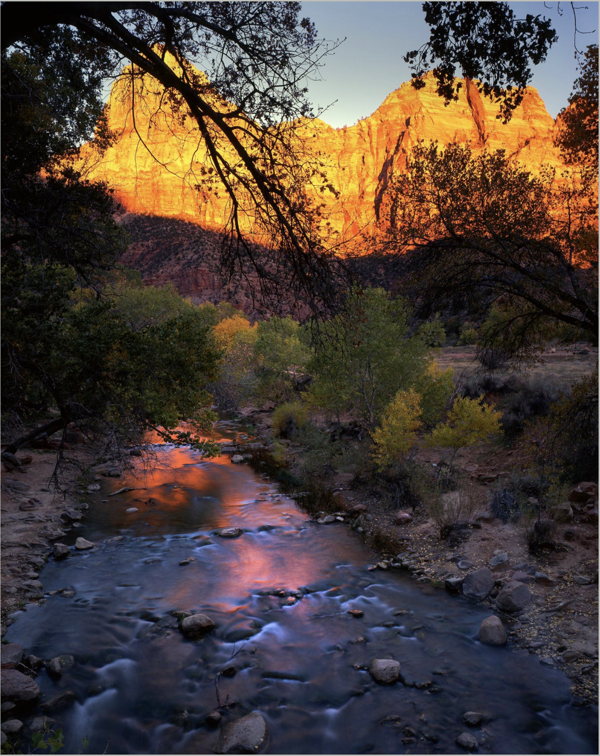 A stream running through a rocky landscape with a mountain in the background.