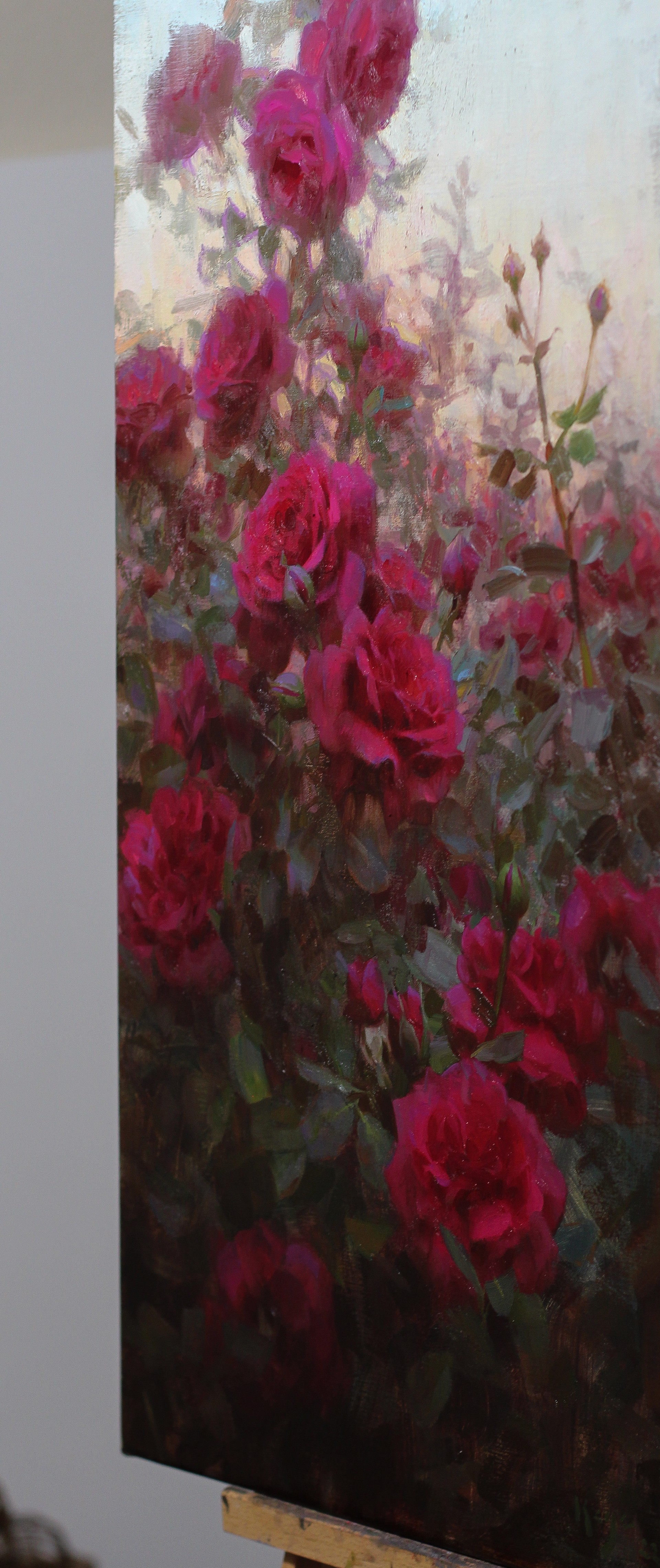 A painting of a bunch of red roses in a field.